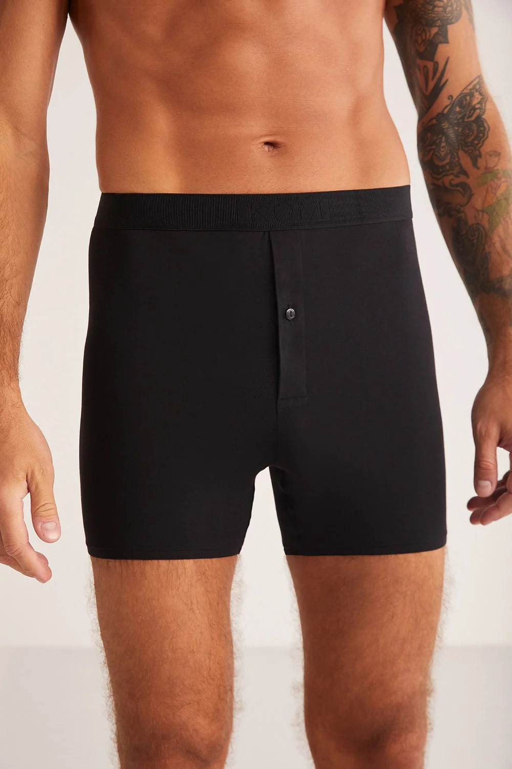 Koyu siyah düğmeli uzun boxers, kom marka erkek iç giyim, modern kıyafet modeli, beyaz arka plan