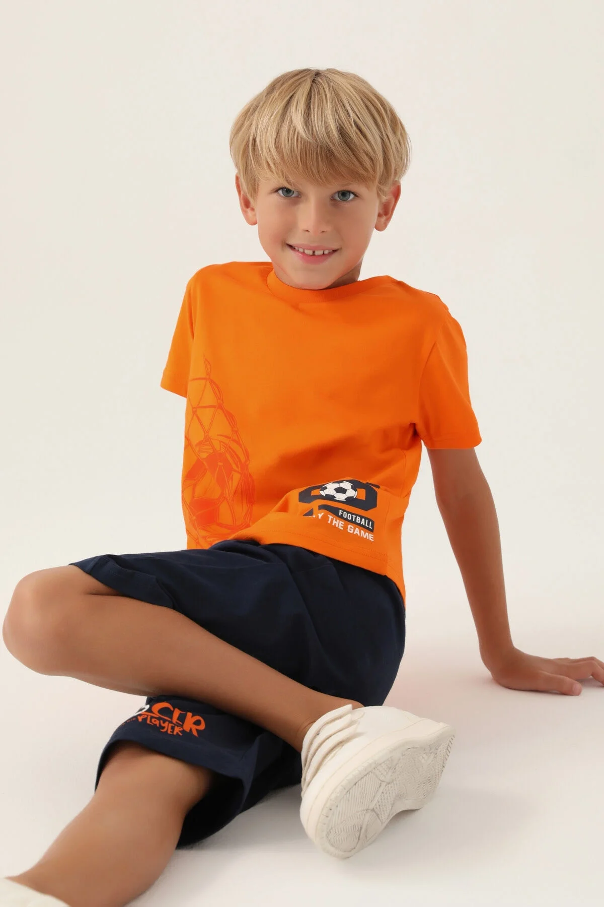 Turuncu kapri takım elbette, Arnetta marka erkek çocuk spor giyimi, futbol desenli t-shirt ve koyu mavi kısa pantolon