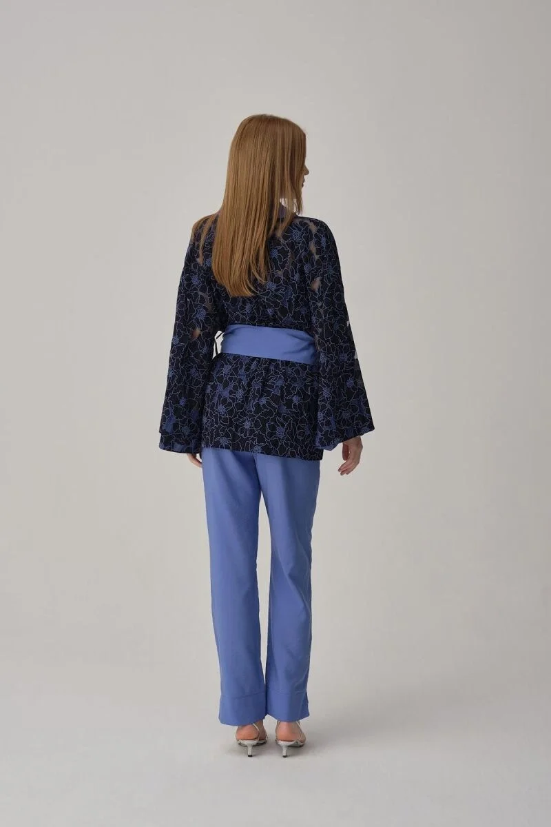 Mavi vegan ipek kimonolu pijama takımını giyen kadın, Pierre Cardin markası, kıyafet detayları ve model pozisyonu