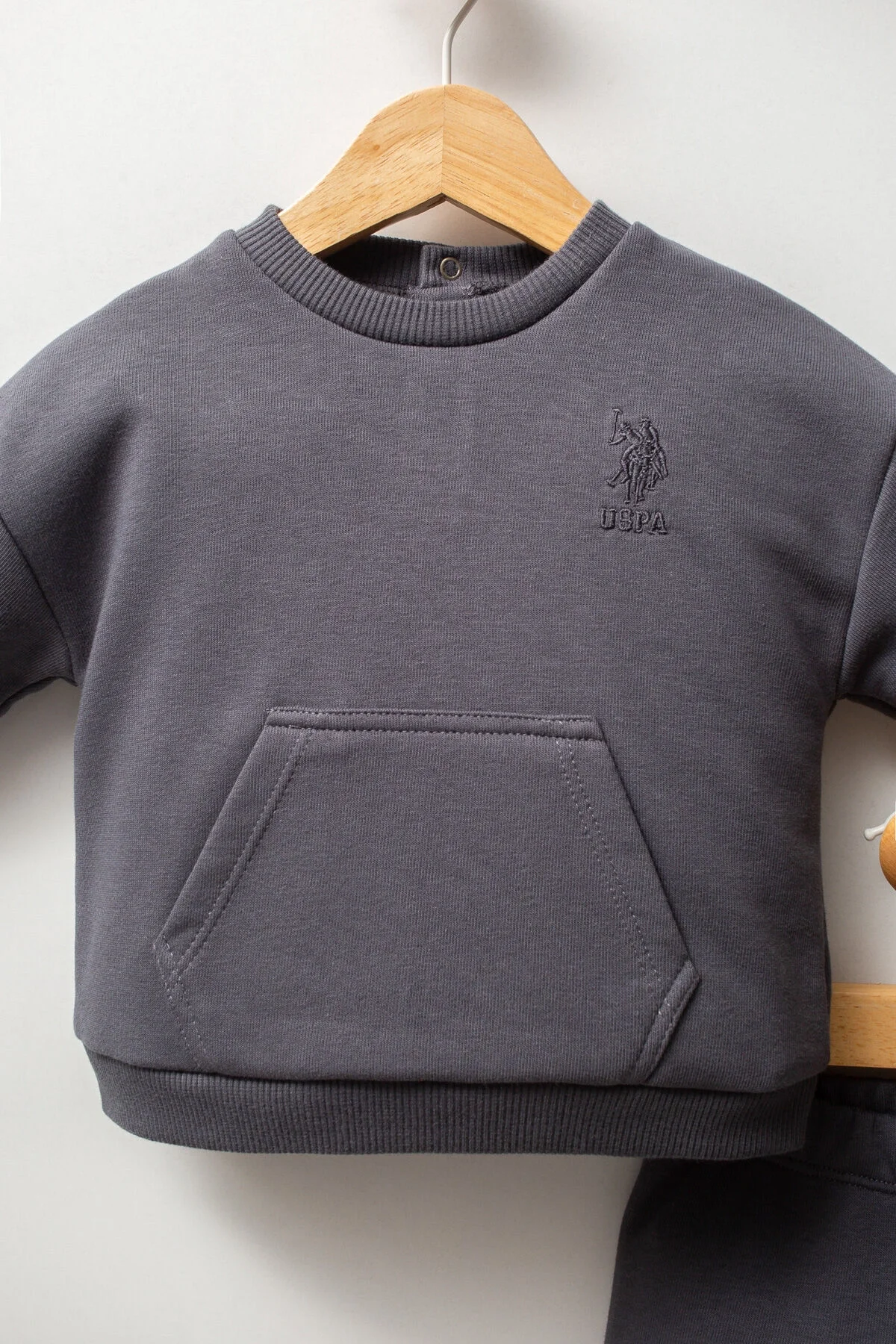 Antrasit renkli U.S. Polo Assn erkek bebek takım elbette, yaka ve pantolon detaylı, marka logosuyla bebek giyim seti