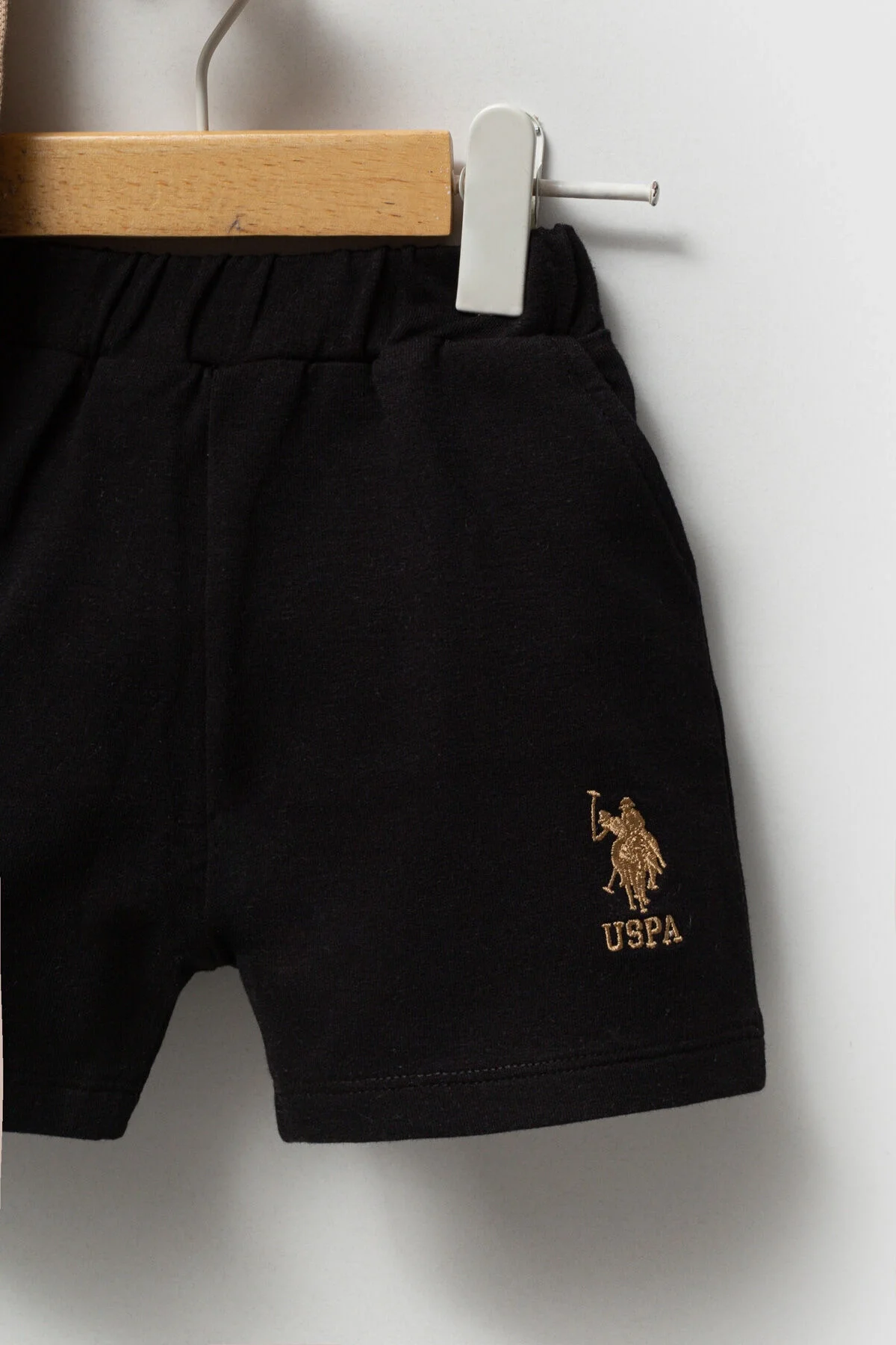 Bej U.S. Polo Assn bebek takım elbette, siyah kısa pantolonlu, marka logosu ile çocuk giyim seti