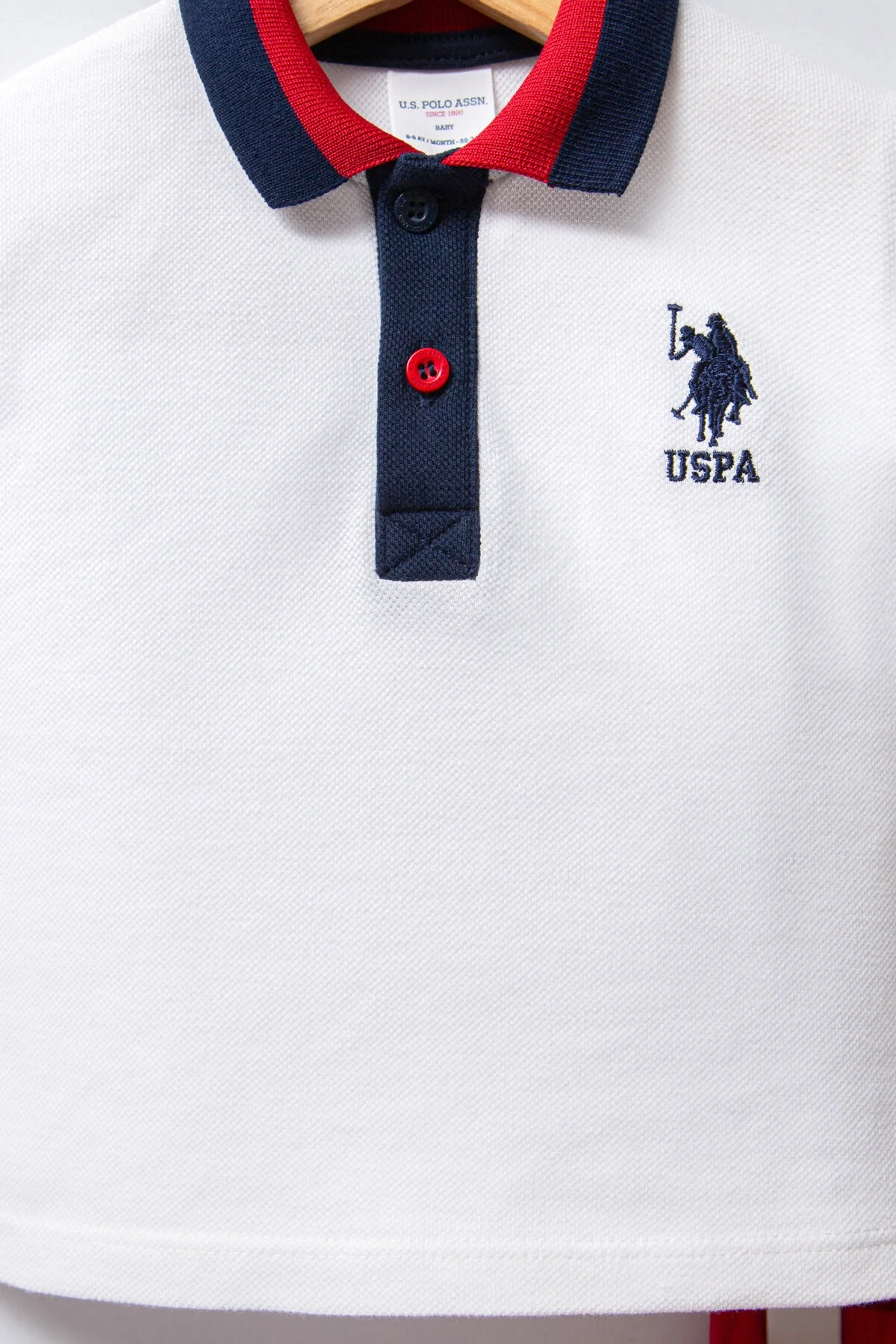 Beyaz polo tişört ve kırmızı kısa pantolonlu U.S. Polo Assn bebek takım elbette, Arnetta markası, çocuk giyim