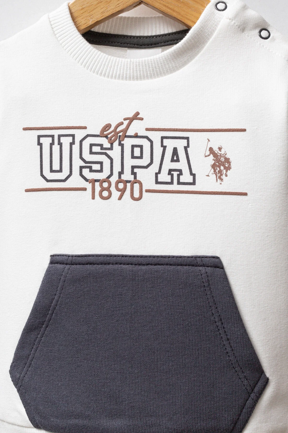 Beyaz ve koyu mavi U.S. Polo Assn bebek takım elbise, üstte ceket, altta pantolon, marka logosu ile çocuk giyim