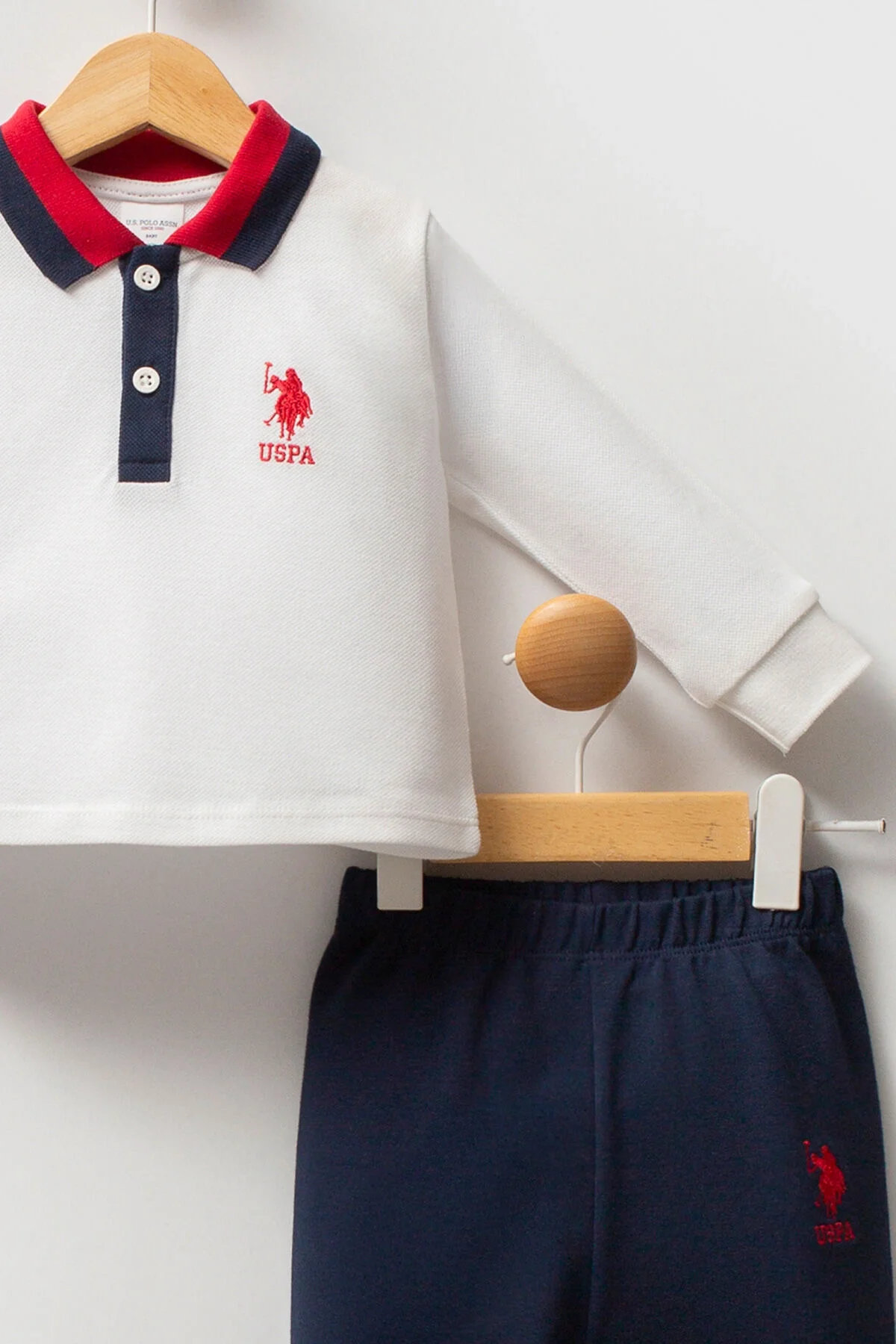 Beyaz uzun kollu polo ve mavi pantolonlu U.S. Polo Assn bebek takım elbise, marka logosu ile çocuk giyim seti