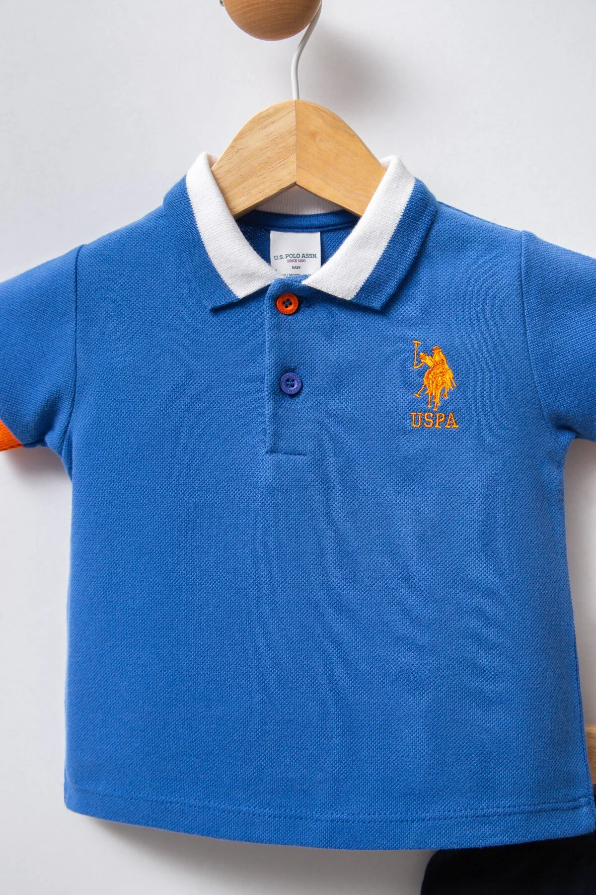 Mavi U.S. Polo Assn bebek takım elbise, koyu mavi kısa pantolon, beyaz yaka, turuncu detaylar, bebek giyim seti