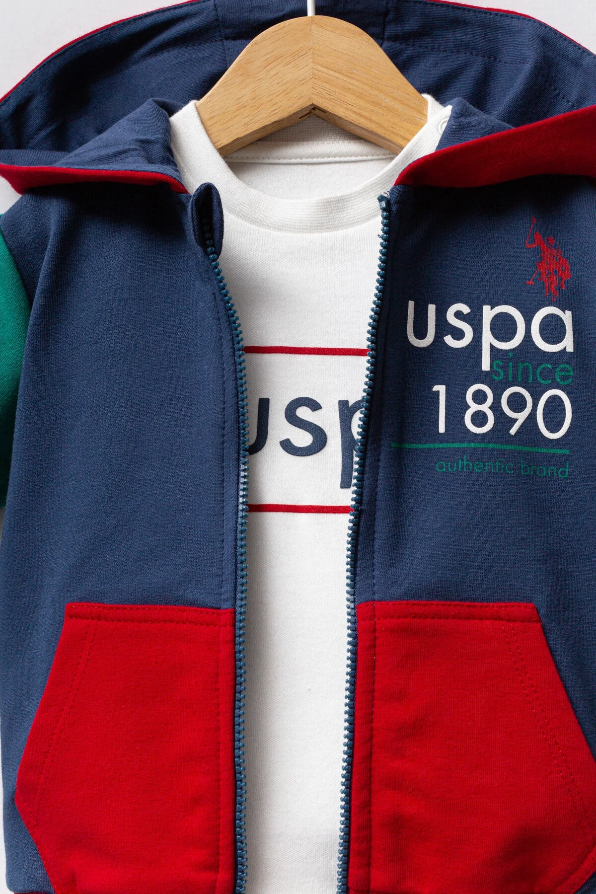 Mavi ve kırmızı detaylı U.S. Polo Assn bebek takım elbise, kapüşonlu ceket ve pantolon, Arnetta markası