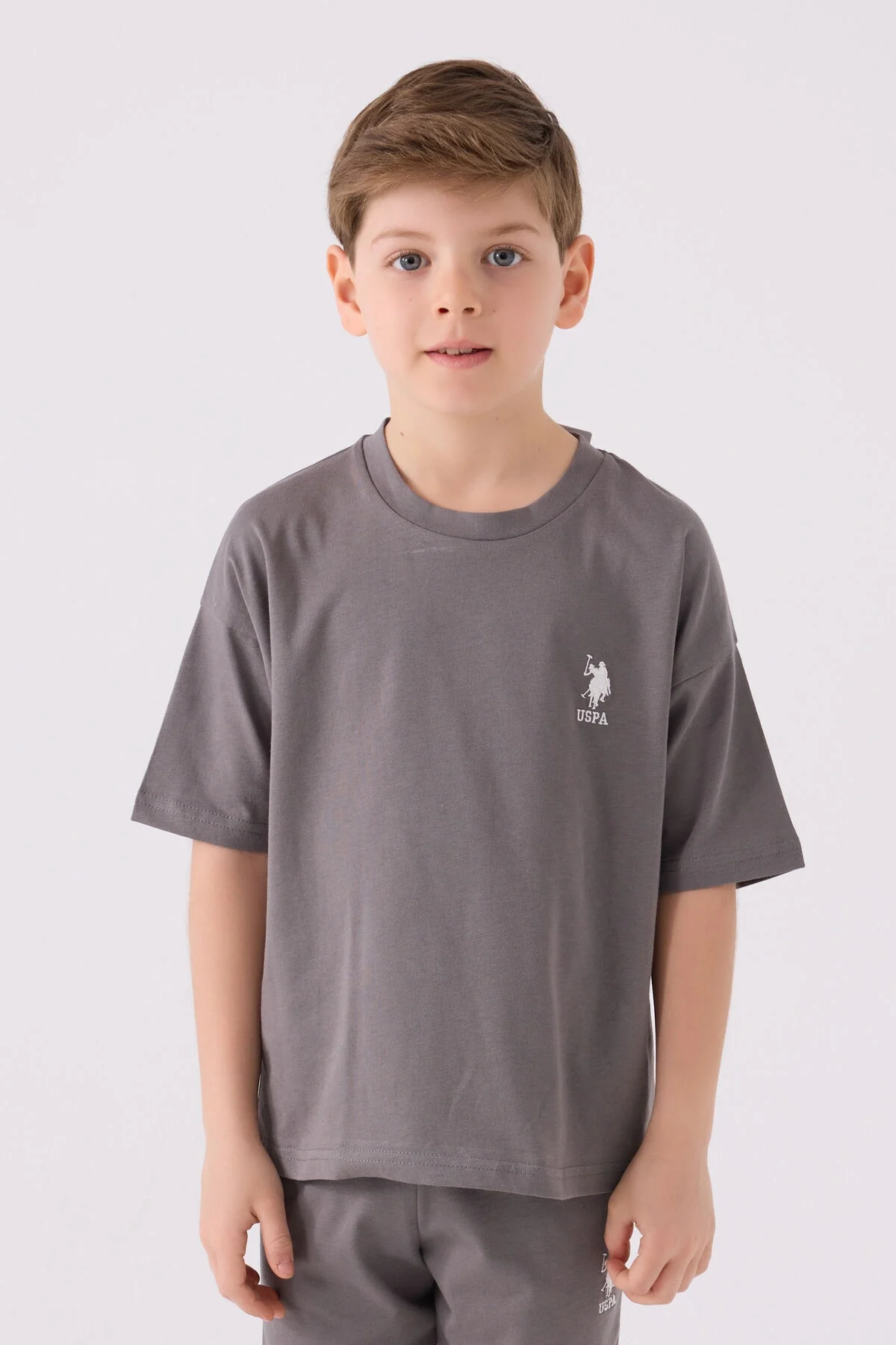Antrasit renkli U.S. Polo Assn erkek çocuk Bermuda takım elbette, üst ve alt parçaları, marka logosu ile detaylı ürün görseli