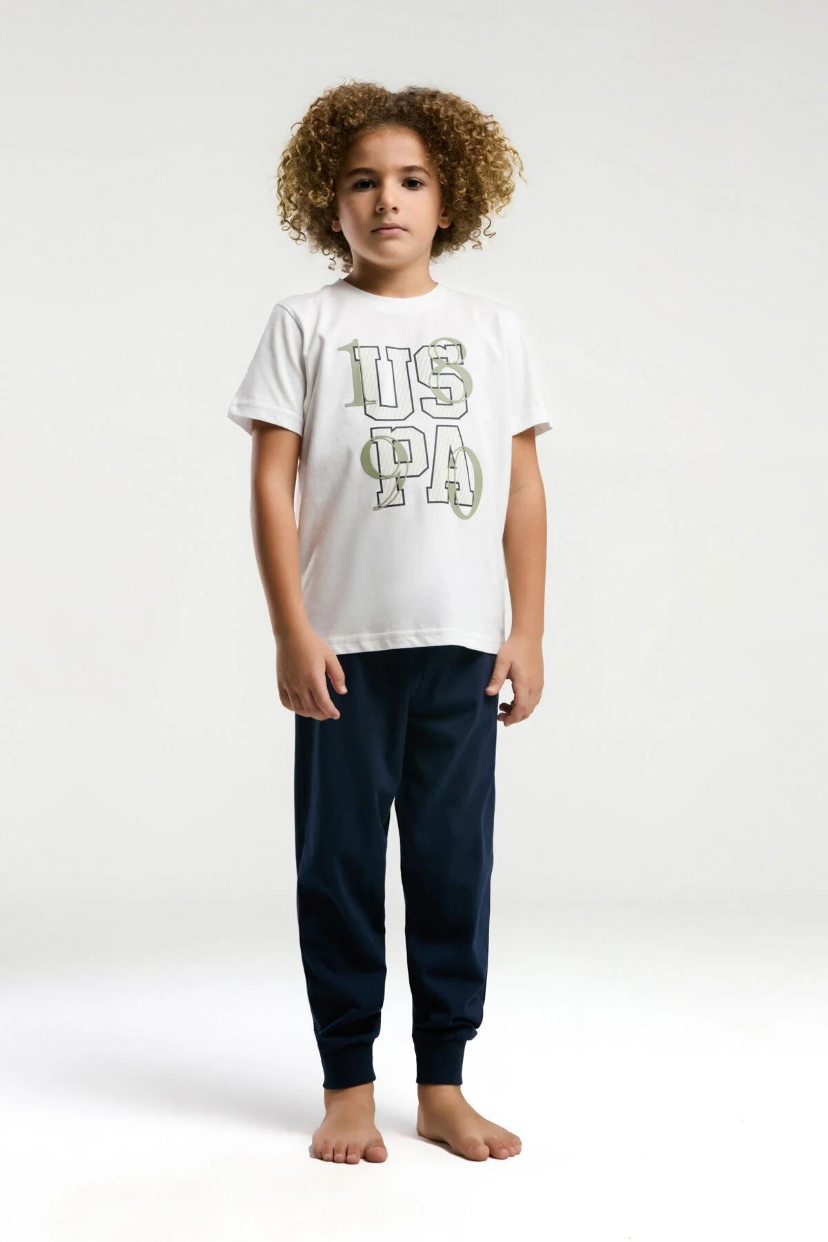 Beyaz US Polo Assn erkek çocuk pijama takımı, üstte 'USPA' yazısı, altta marka logosu, çocuk modeli