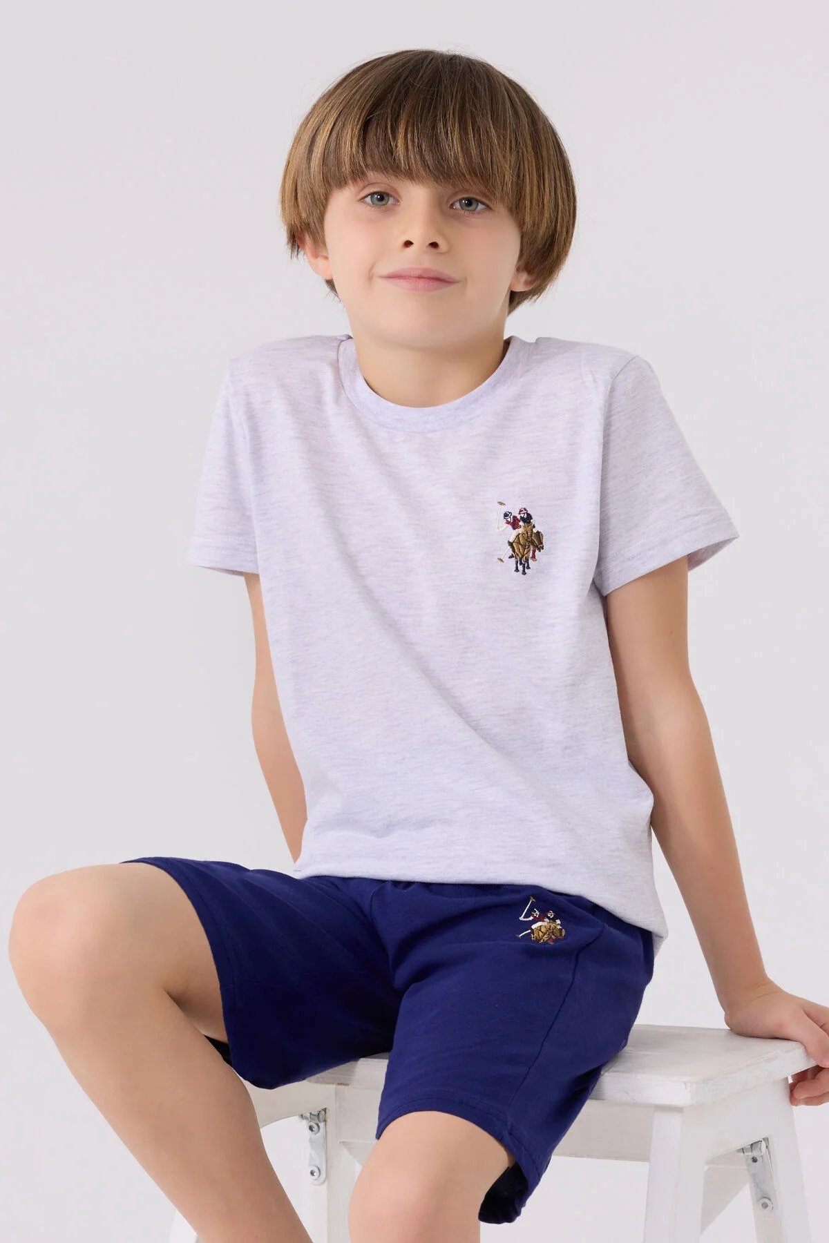 Gri üst ve mavi Bermuda kısa pantolonlu U.S. Polo Assn erkek çocuk takım elbise, marka logosu ile detaylı ürün görseli