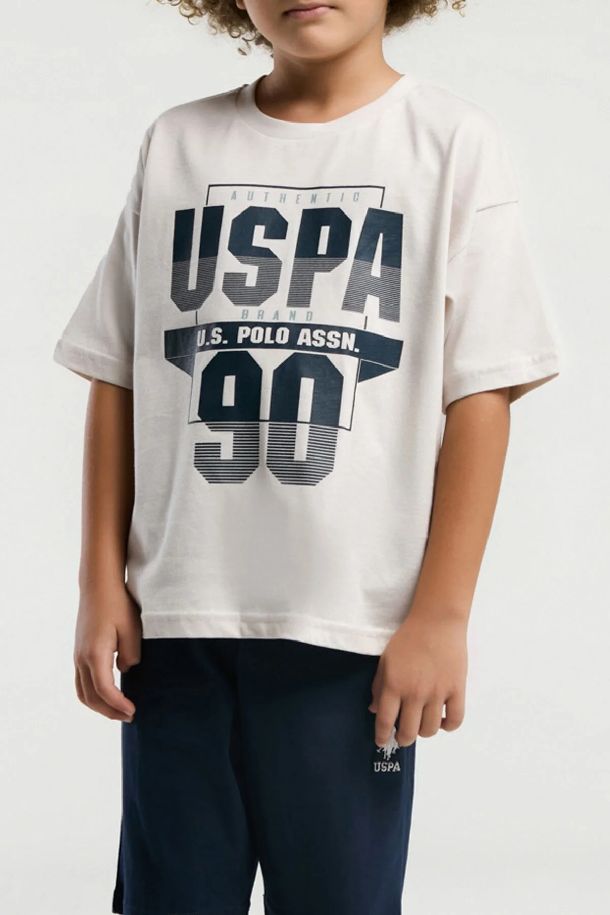 U.S. Polo Assn Erkek Çocuk Krem Bermuda Takım, 90 numaralı grafik tişört ve mavi kısa pantolon, çocuk giyim modeli