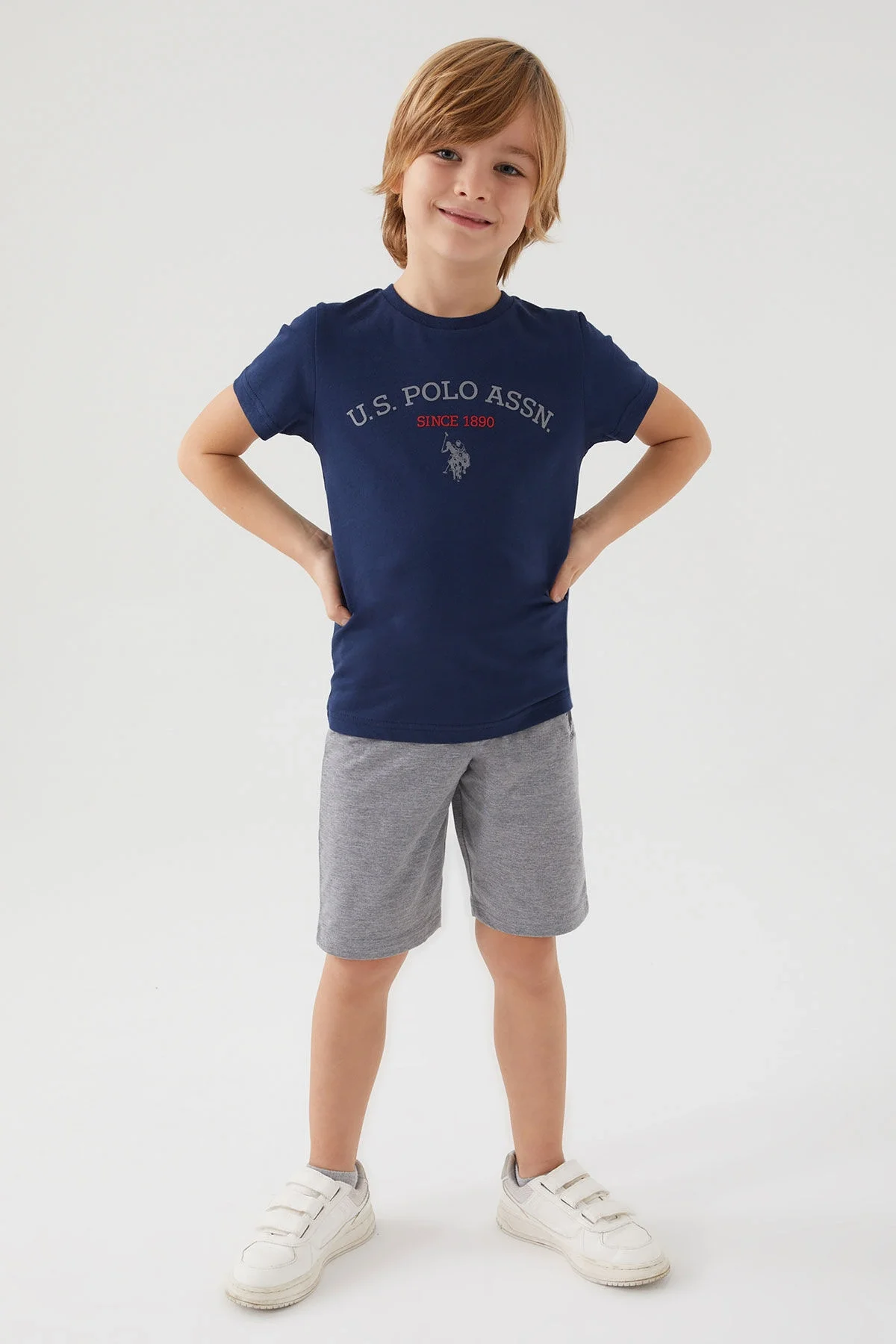 U.S. Polo Assn Erkek Çocuk Lacivert Bermuda Takım, gri kısa pantolon ve beyaz spor ayakkabı ile çocuk modeli