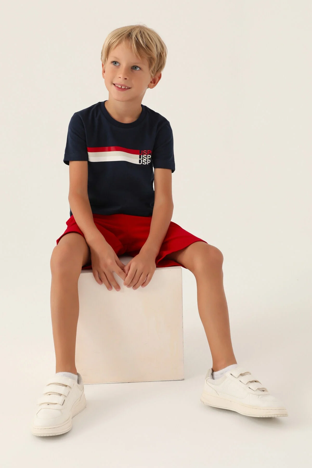 U.S. Polo Assn Erkek Çocuk Lacivert Bermuda Takım, kırmızı kısa pantolon ve beyaz spor ayakkabıyla tamamlayan çocuk giyim seti