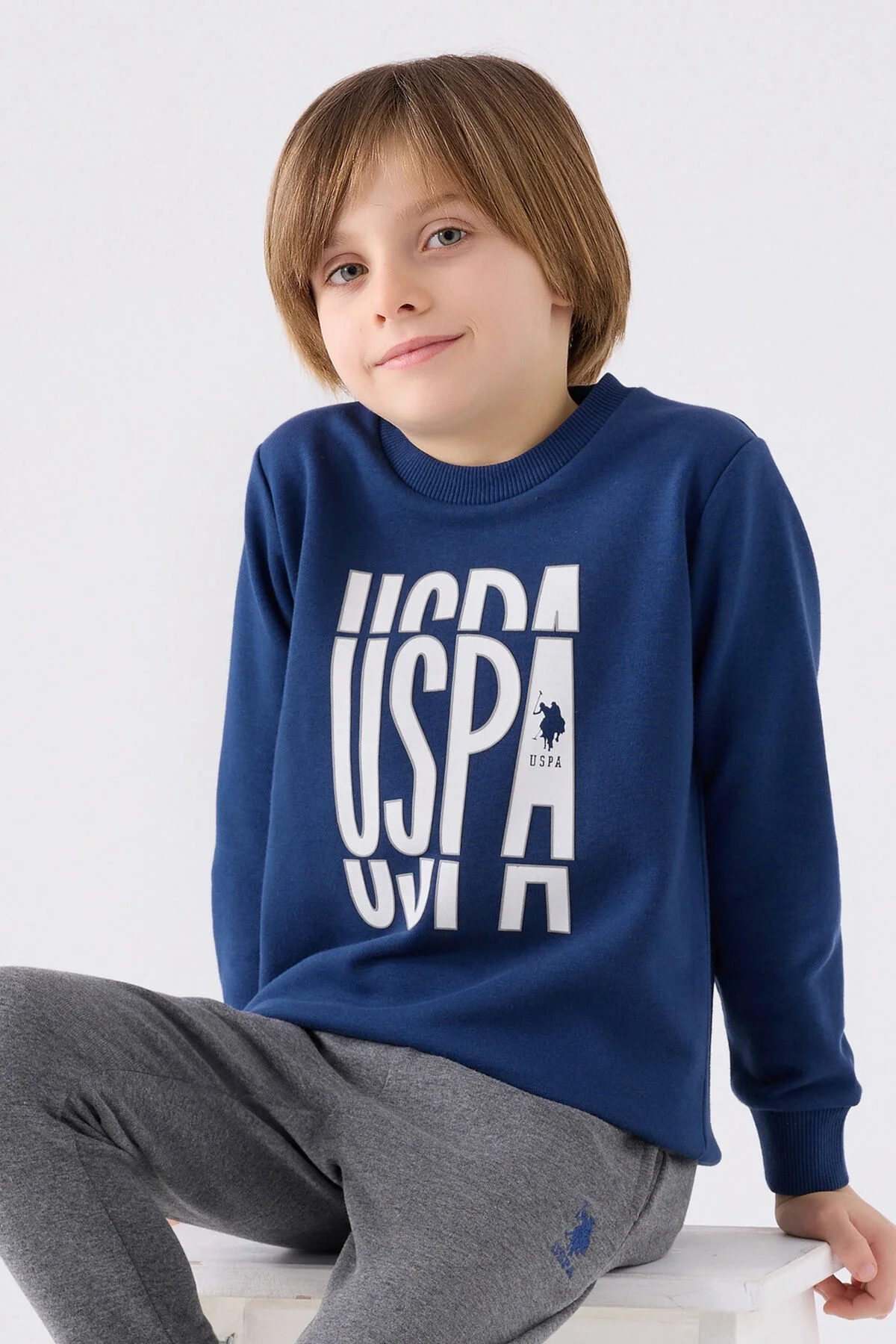 U.S. Polo Assn Erkek Çocuk Lacivert Eşofman Takımı, gri pantolon ve mavi spor ayakkabı, marka logosu ile çocuk giyim
