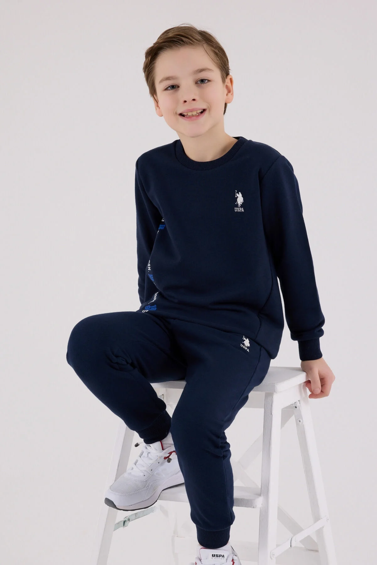 Lacivert U.S. Polo Assn erkek çocuk eşofman takımı, model ön görünüm, marka logosu ve yazı detayları