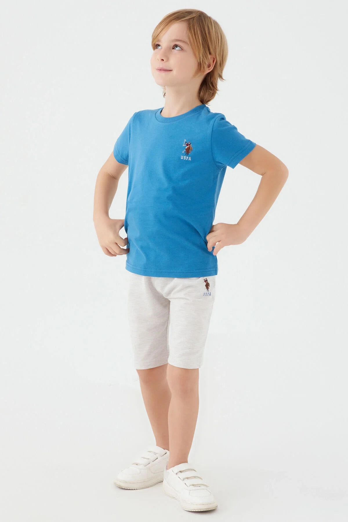 Mavi U.S. Polo Assn erkek çocuk Bermuda takım elbette, beyaz ayakkabılarla birlikte oturmuş çocuk modeli