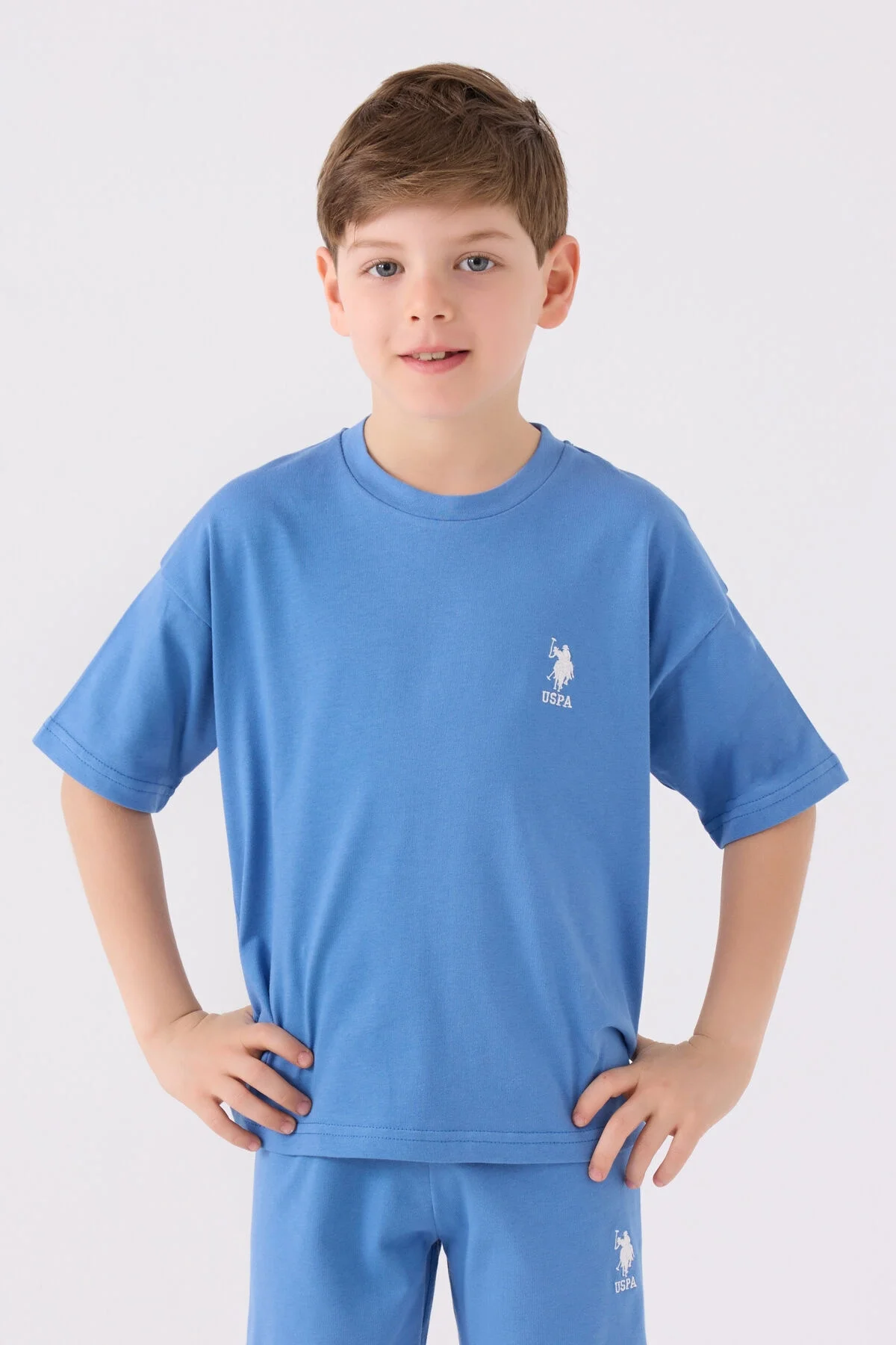 Mavi U.S. Polo Assn erkek çocuk Bermuda takım elbette, ön ve yan görünüm, marka logosu ve spor ayakkabılarla takımlı