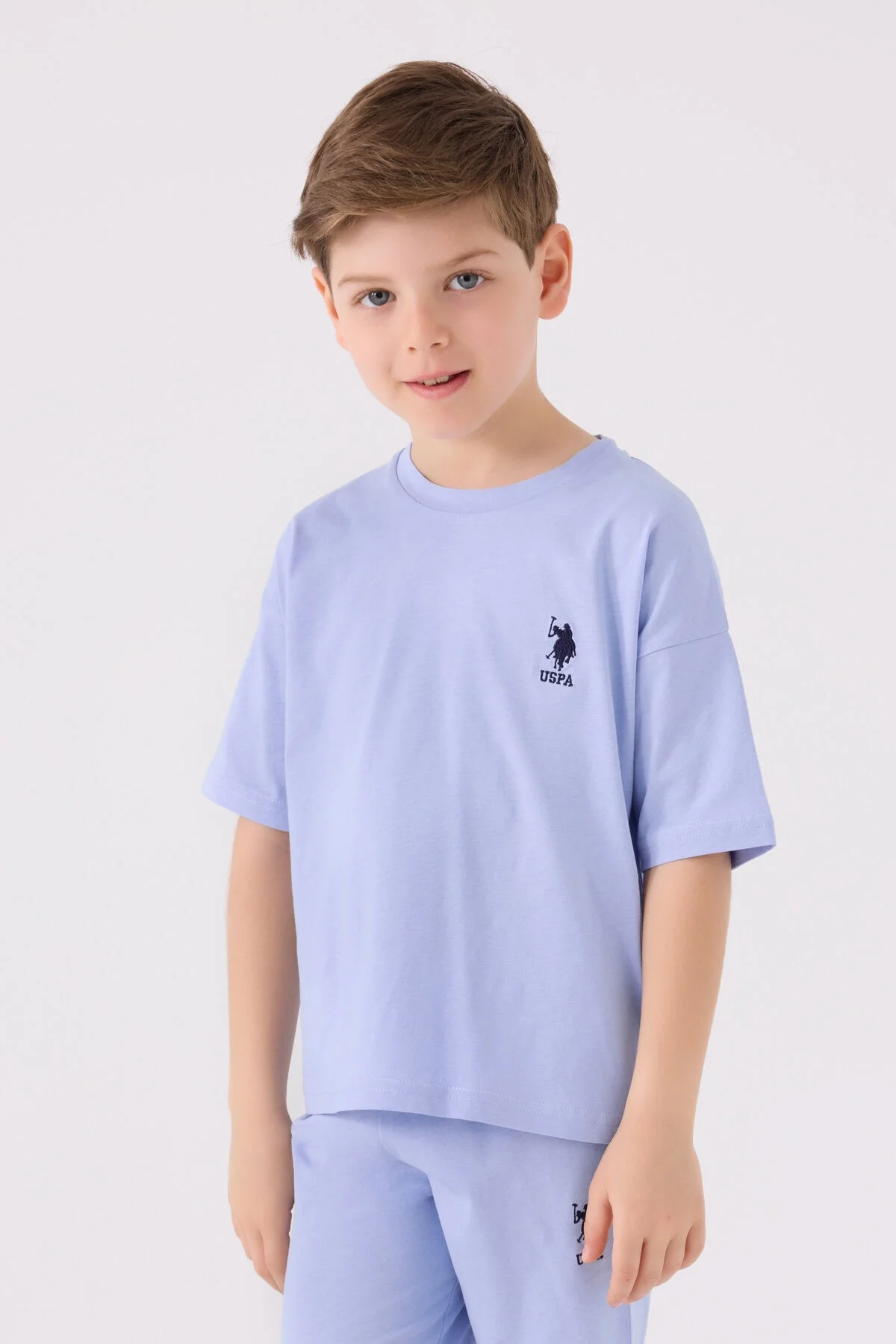Mavi U.S. Polo Assn erkek çocuk Bermuda takım elbette, görselde çocuk pozitif ifadeyle ön görünüm