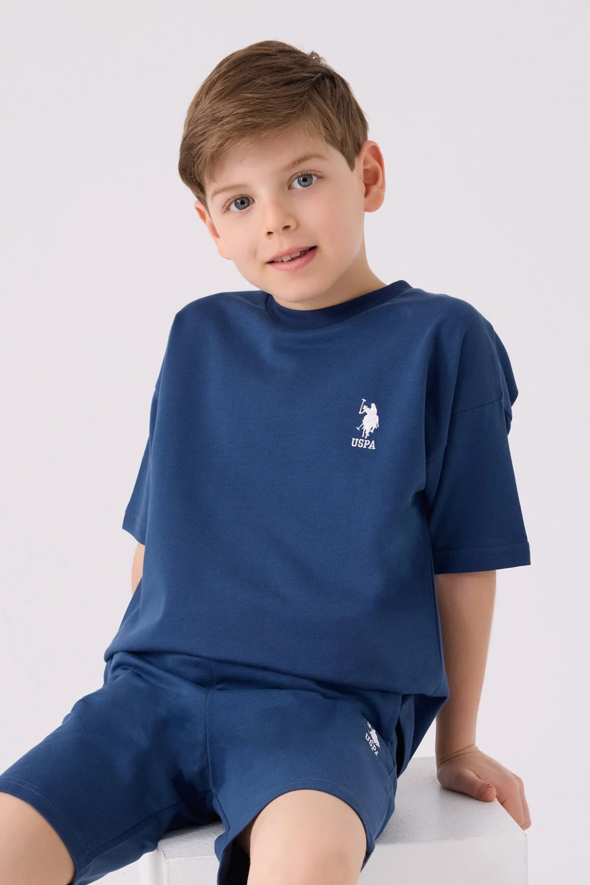 Mavi U.S. Polo Assn erkek çocuk Bermuda takım elbette, marka logosu ve spor stilindeki çocuk giyim seti
