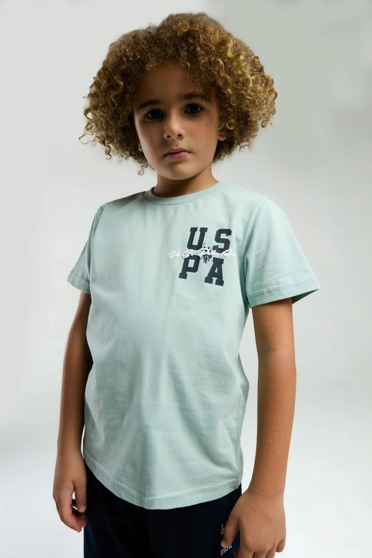 Mavi Bermuda takım elbette, U.S. Polo Assn çocuk markası, erkek çocuk giyim, beyaz arka plan, model pozisyonu