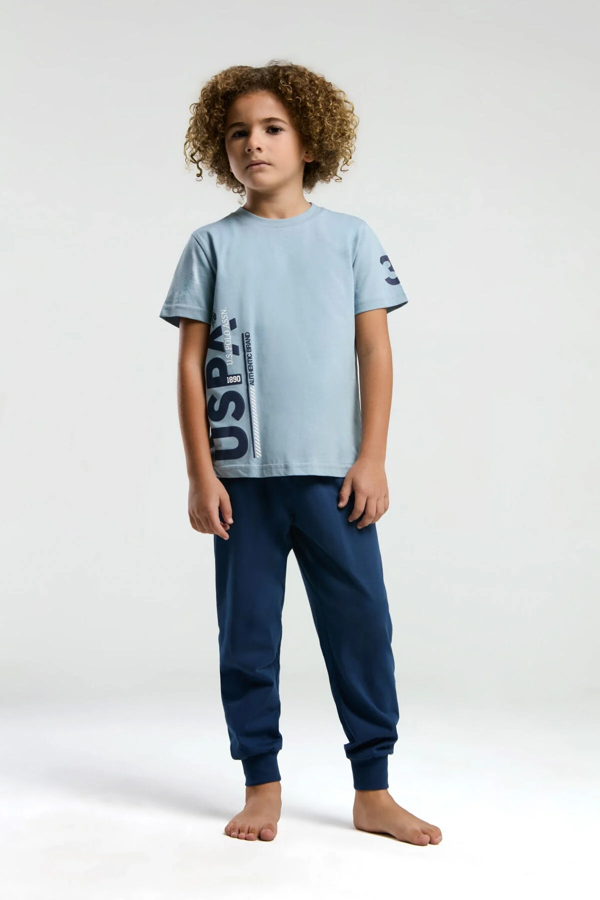 Mavi U.S. Polo Assn erkek çocuk pijama takımı, üstte marka yazısı, pantolonunun koyu mavi rengi, çocuk modeli
