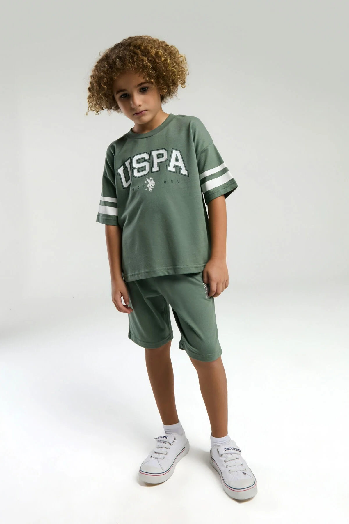 Yeşil USPA markalı erkek çocuk Bermuda takım elbette, kollarında beyaz çizgiler, spor tarzı model