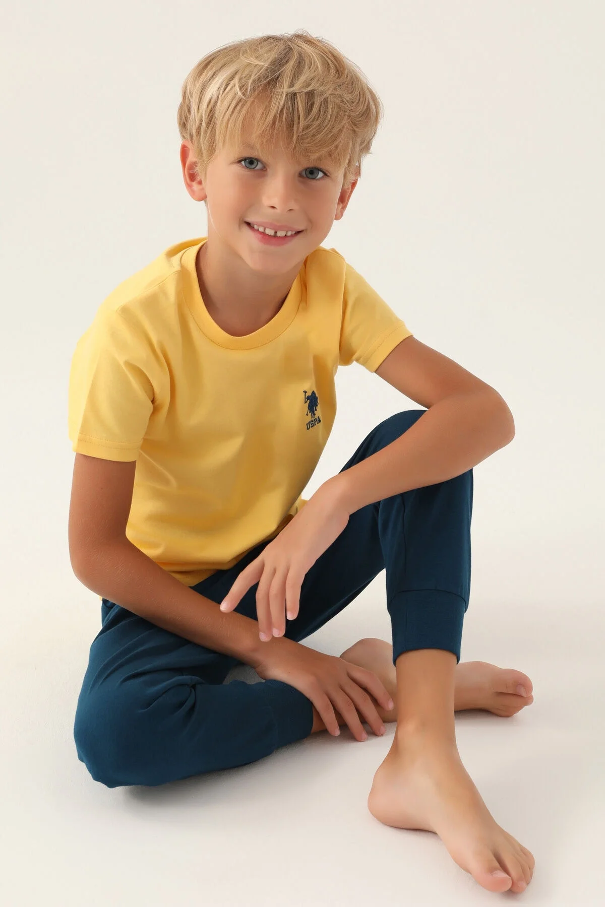 U.S. Polo Assn Erkek Çocuk Yeşil Pijama Takımı, koyu mavi pantolon ve sarı tişört, çocuk modeli, marka logosu, rahat günlük giyim