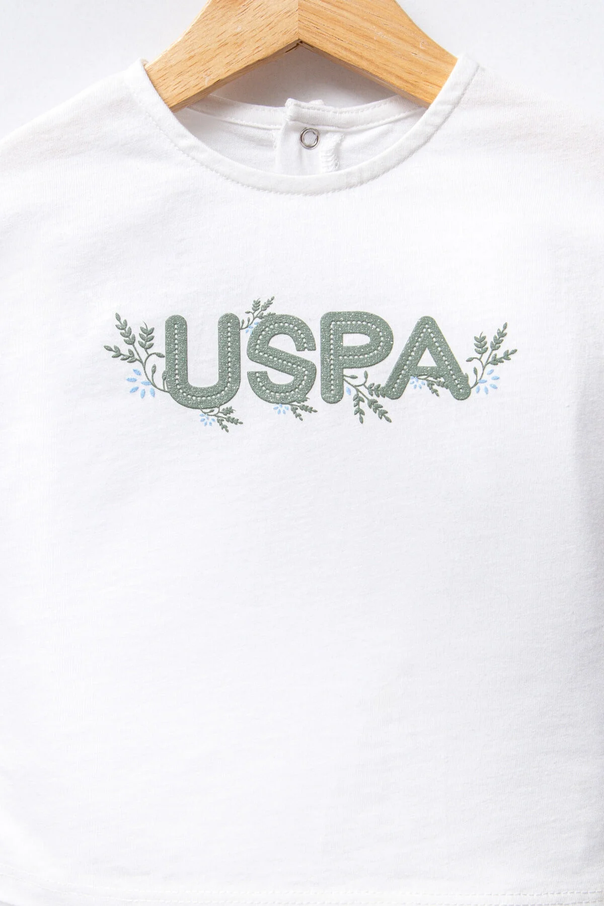 Beyaz U.S. Polo Assn kız bebek takım elbise, ruffle kollu üst ve desenli pantolon, Arnetta markası, bebek giyim