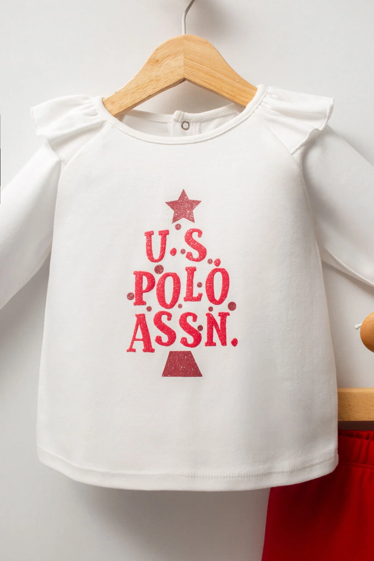 Beyaz U.S. Polo Assn. kız bebek takım elbette, kırmızı pantolon ve dantelli üst, bebeğin giyimini gösteren ürün fotoğrafı