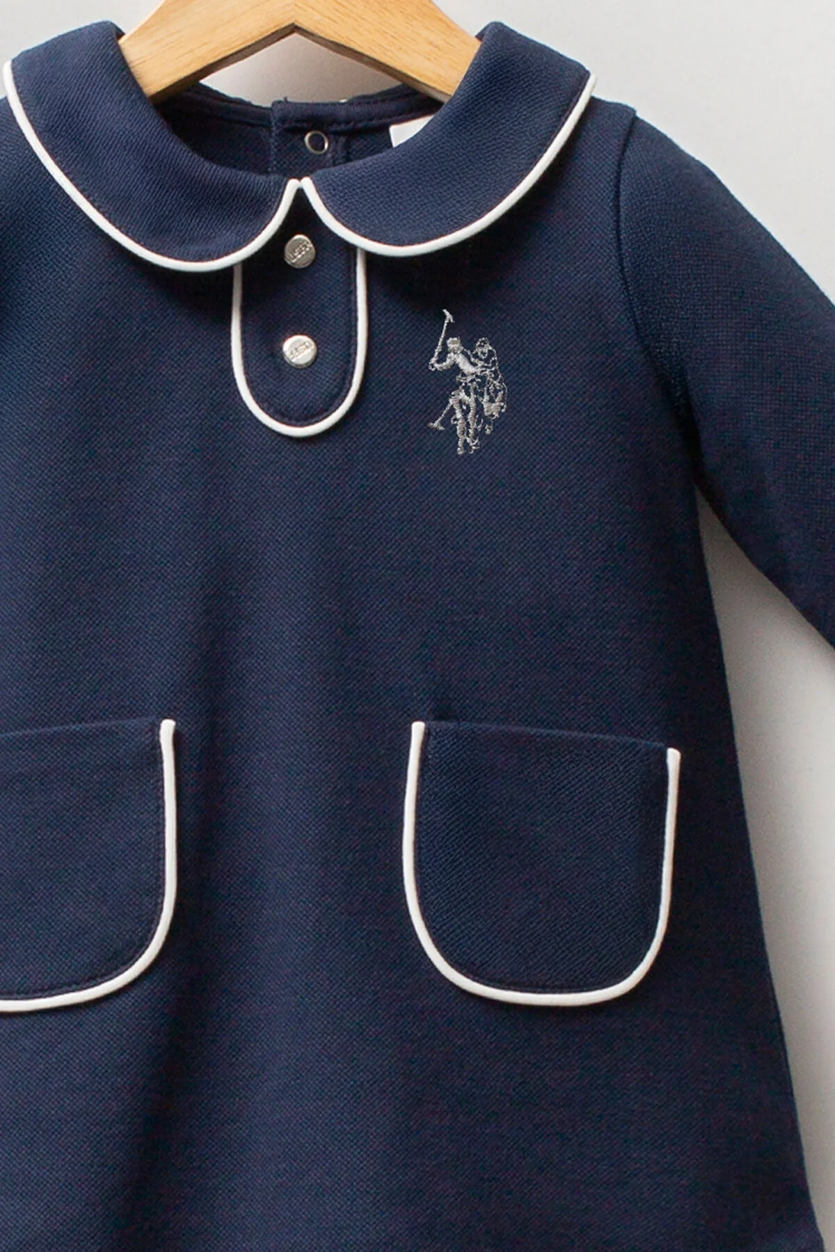 Lacivert U.S. Polo Assn kız bebek elbise, kolları ve cebi beyaz detaylı, marka logosu ön tarafında, arnetta markası