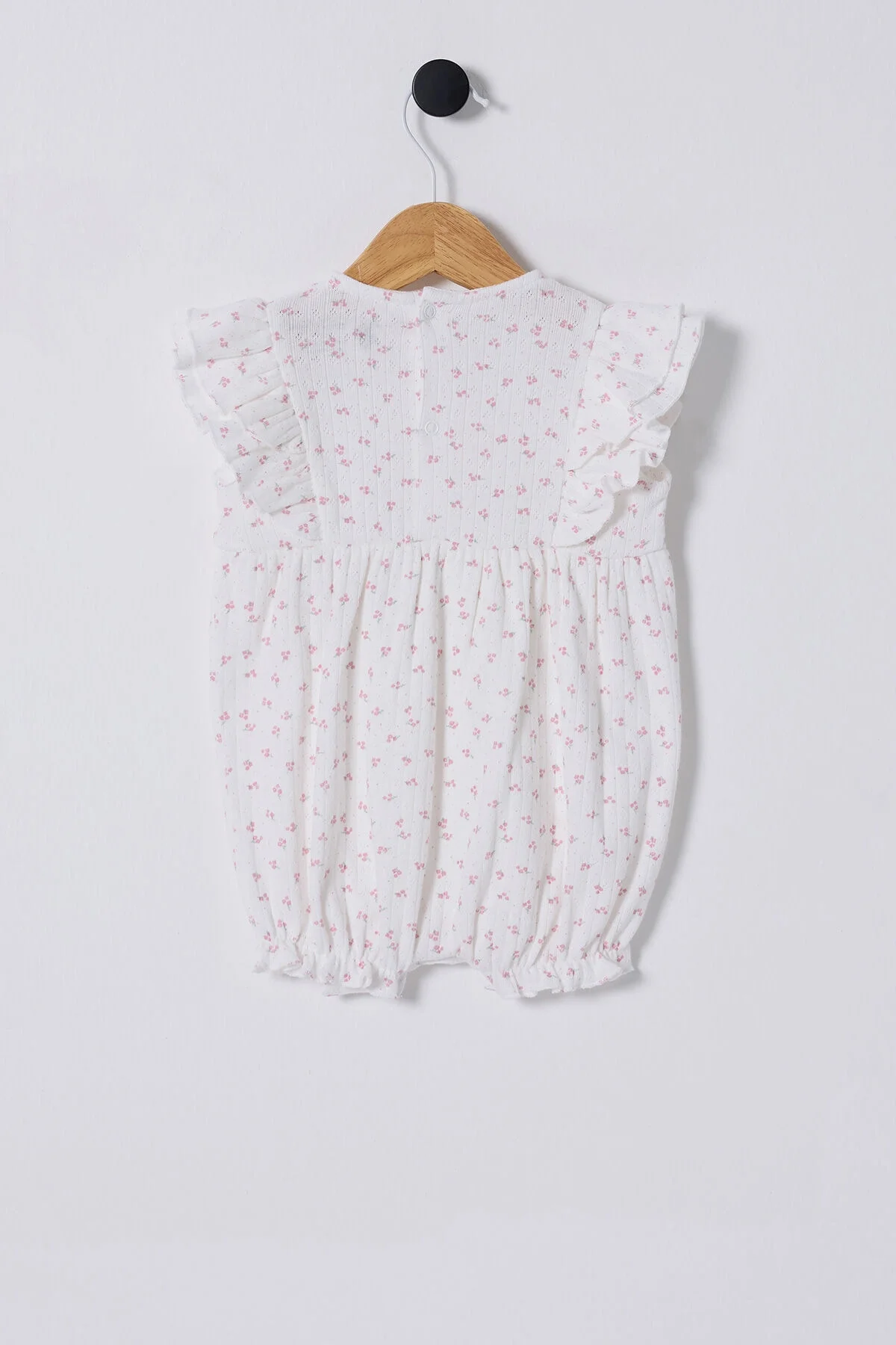 Pembe çiçek desenli U.S. Polo Assn kız bebek tulum, yumuşak dokulu, ruffles detaylı, arka planlı ürün fotoğraf