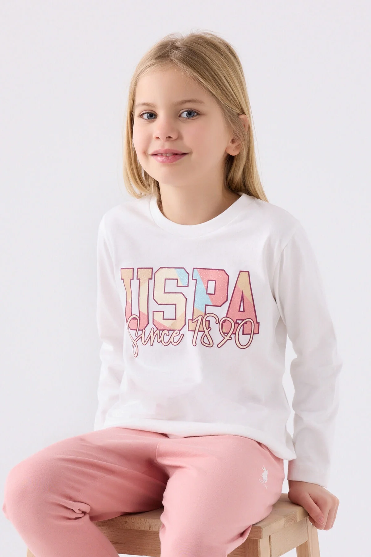 Beyaz uzun kollu üst ve pembe pantolonlu kız çocuk pijama takımı, USA markası, U.S. Polo Assn desenli, erişilebilirlik optimizasyonu