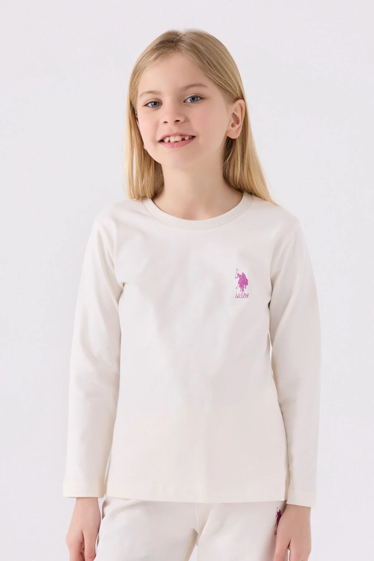 Beyaz U.S. Polo Assn kız çocuk pijama takımı, uzun kollu üst ve pantolon, ön ve yan detaylı, marka logosu ile çocuk giyim