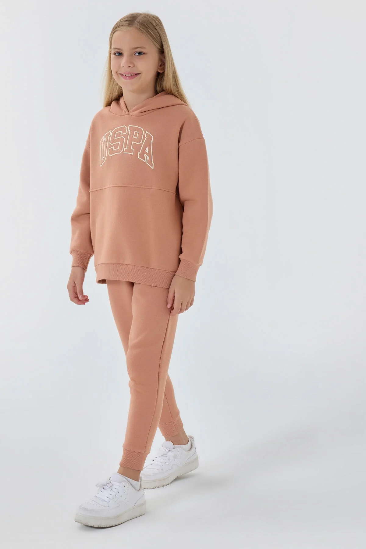 Bordo USPA logosu olan kız çocuk eşofman takımı, rahat jogger pantolon ve kapüşonlu üst, beyaz spor ayakkabılarla takımlı