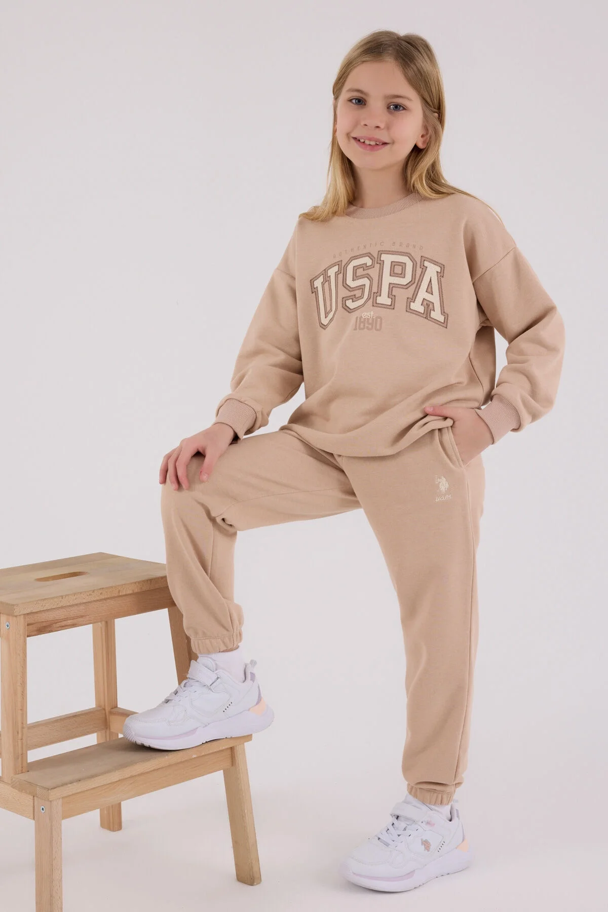 Kız çocuk kahverengi USPA eşofman takımı, rahat spor stil, ön görsel, model pozisyonu, beyaz arka plan