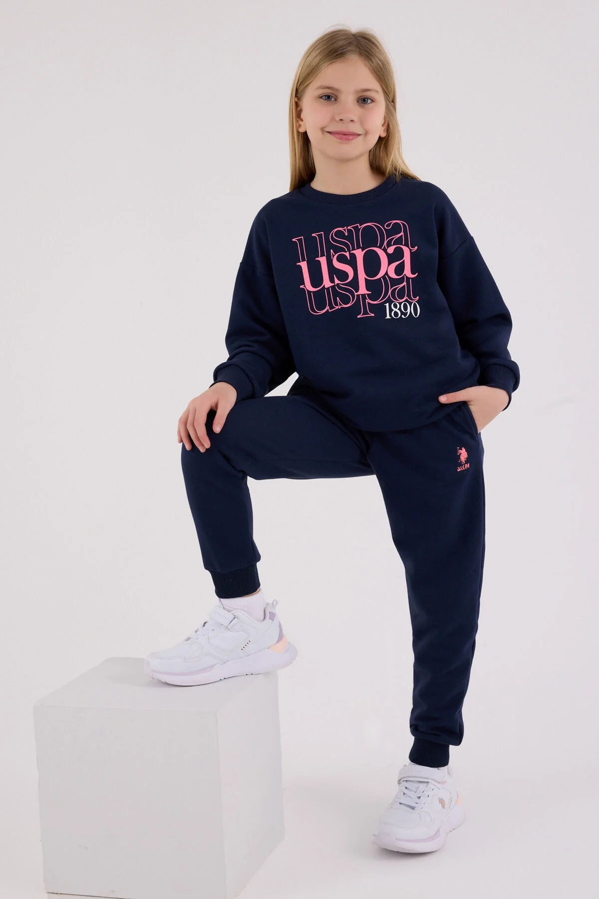 Lacivert USPA marka kız çocuk eşofman takımı, ön görsel, 1890 yazılı, spor stil, beyaz spor ayakkabılarla