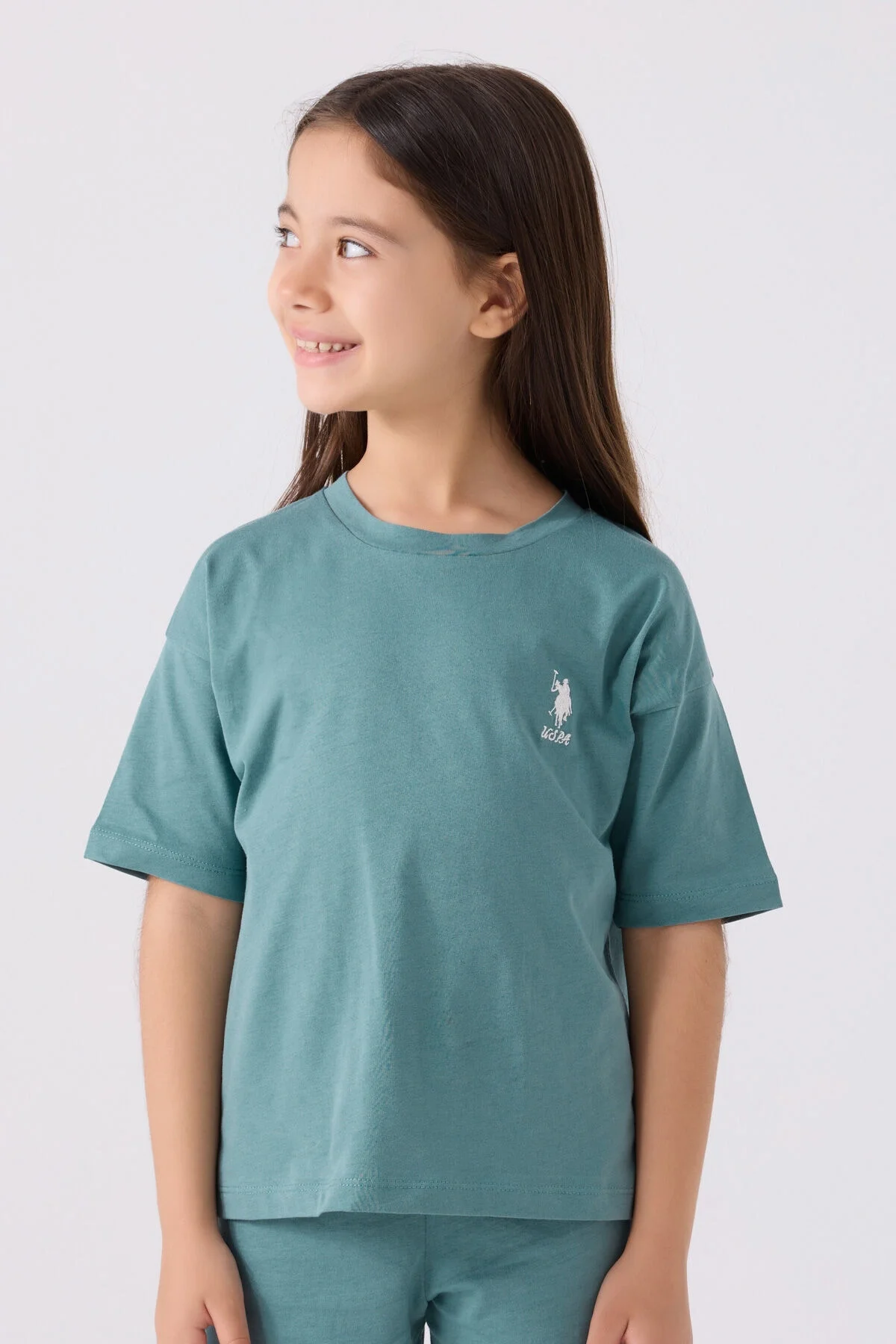 Mavi Bermuda takım seti, U.S. Polo Assn marka kız çocuk giyim, beyaz ayakkabı ile model pozisyonu