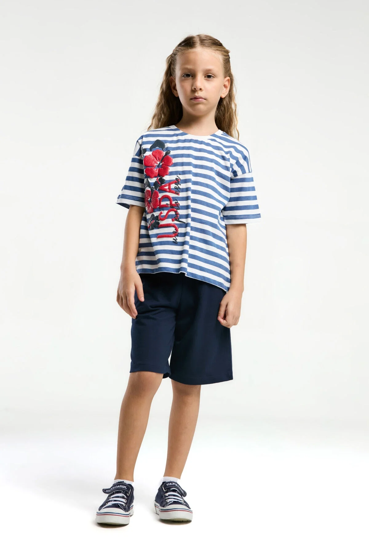 Mavi beyaz çizgili U.S. Polo Assn kız çocuk Bermuda takım elbette, kırmızı dantelli çiçek ve logo detaylı
