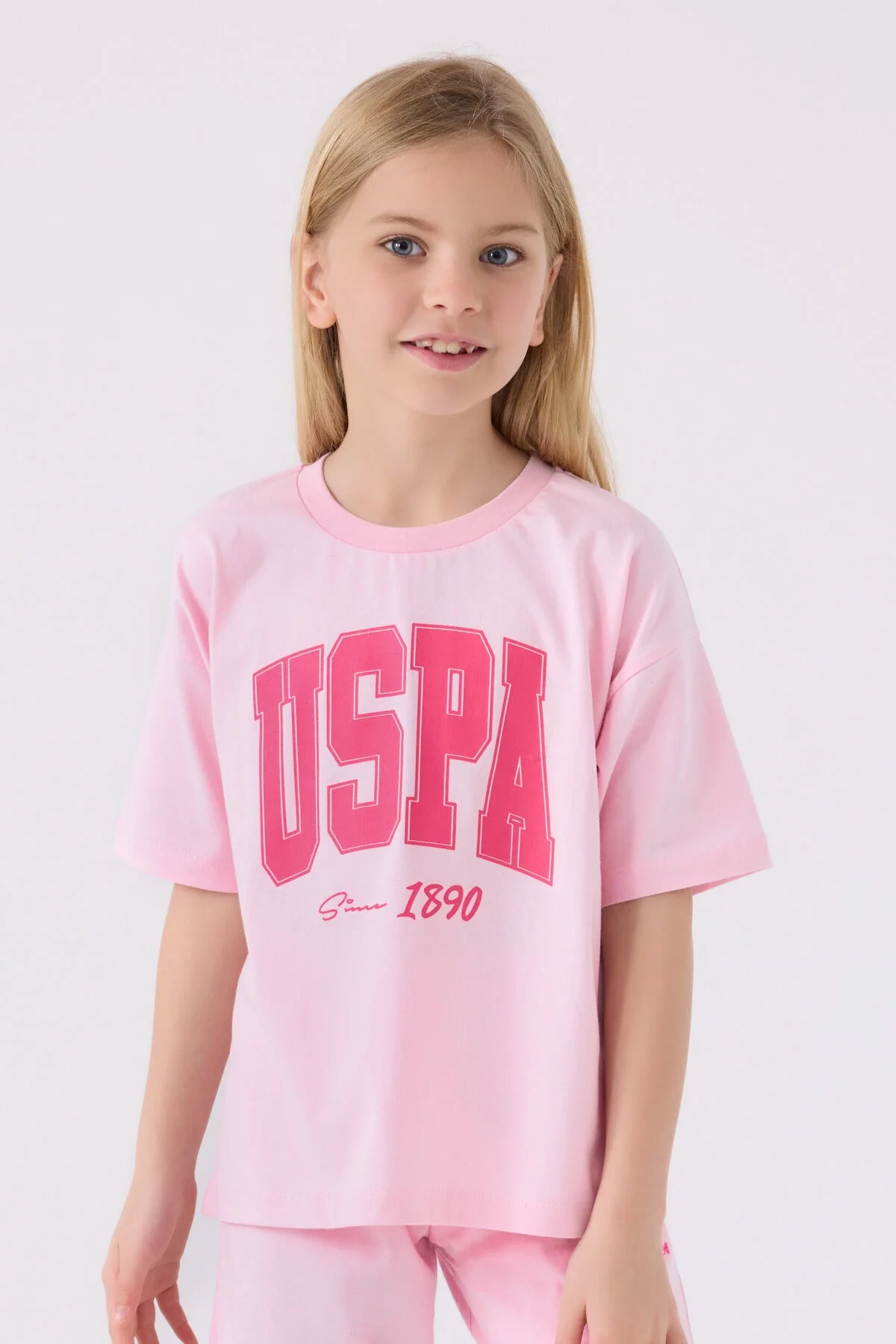 Pembe USPA marka kız çocuk Bermuda takım elbette, 1890 yazısı, beyaz spor ayakkabılarla tamamlayan yazlık giyim seti