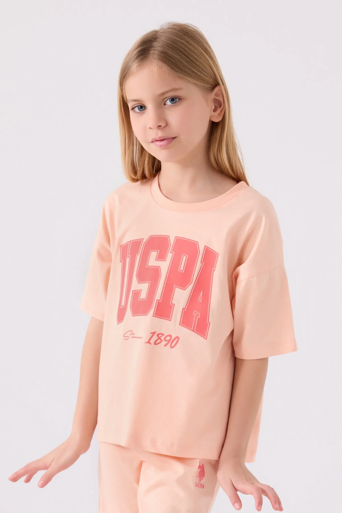 Pembe USPA kız çocuk Bermuda takım elbette, 1890 yazısı, beyaz spor ayakkabılarla takımlı çocuk model