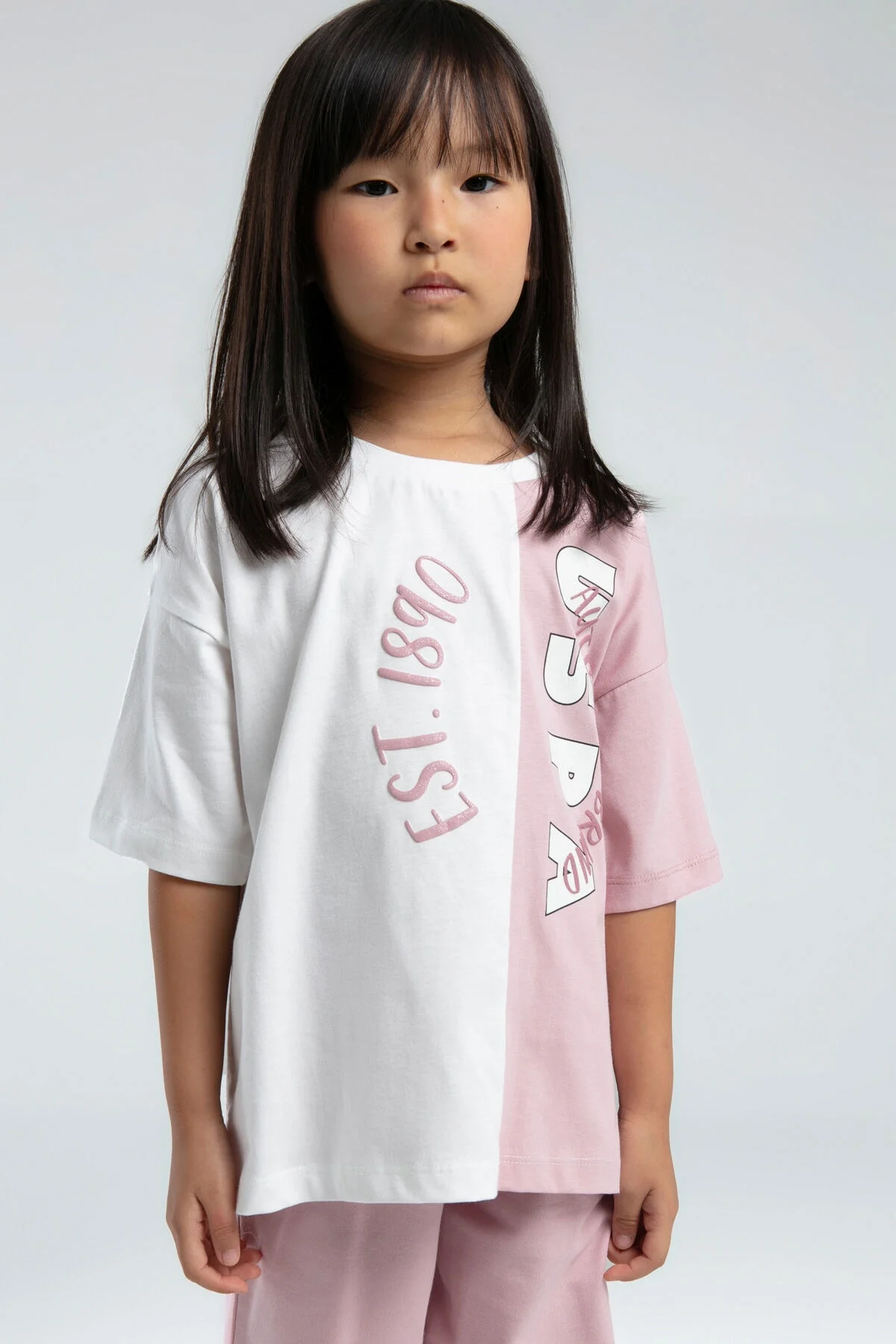 Pembe ve beyaz iki tonlu U.S. Polo Assn kız çocuk Bermuda takım, EST.1890 yazısı, çocuk giyim modeli