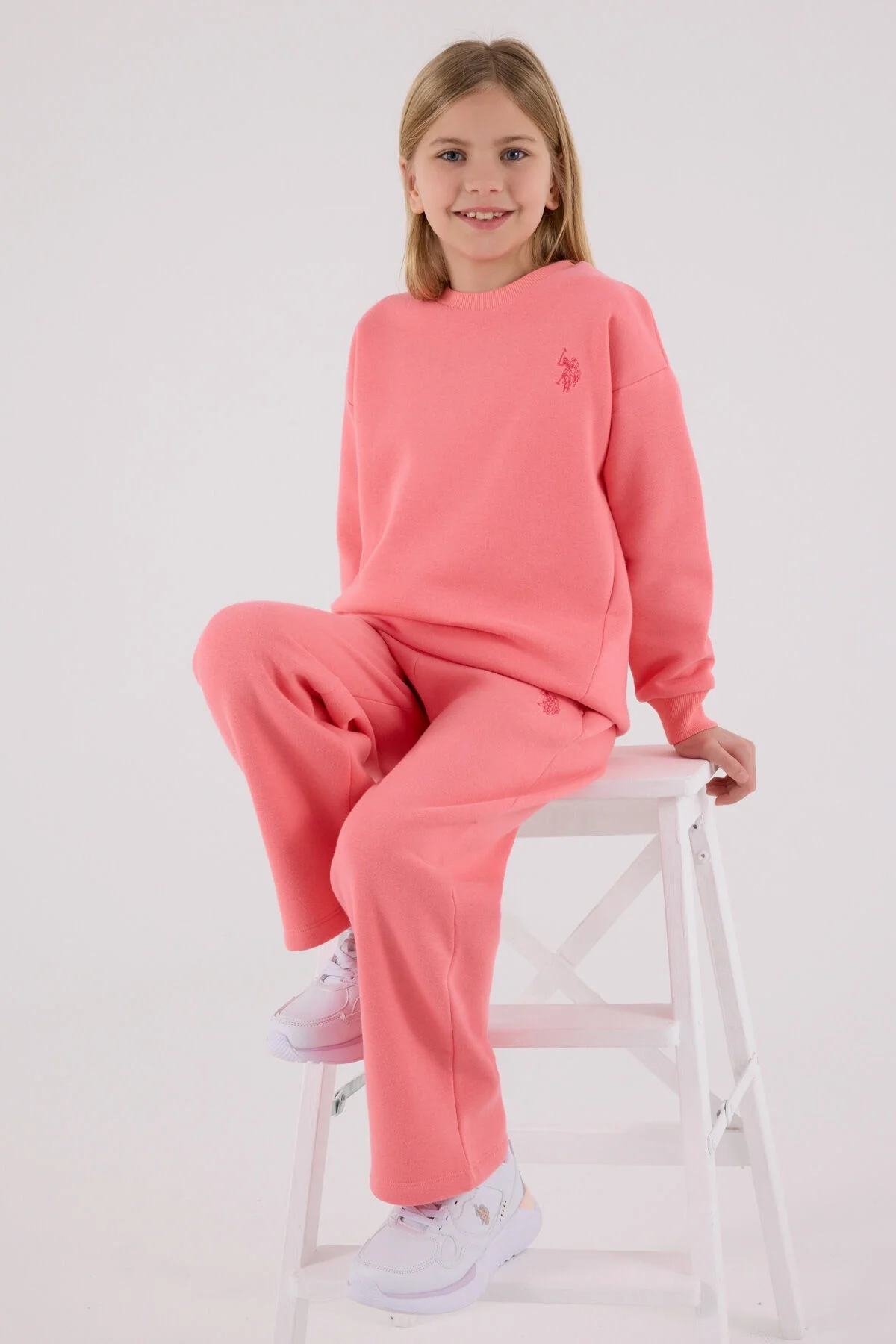 Pembe U.S. Polo Assn kız çocuk eşofman takımı, model ön görünüm, rahat kıyafet, marka logosu