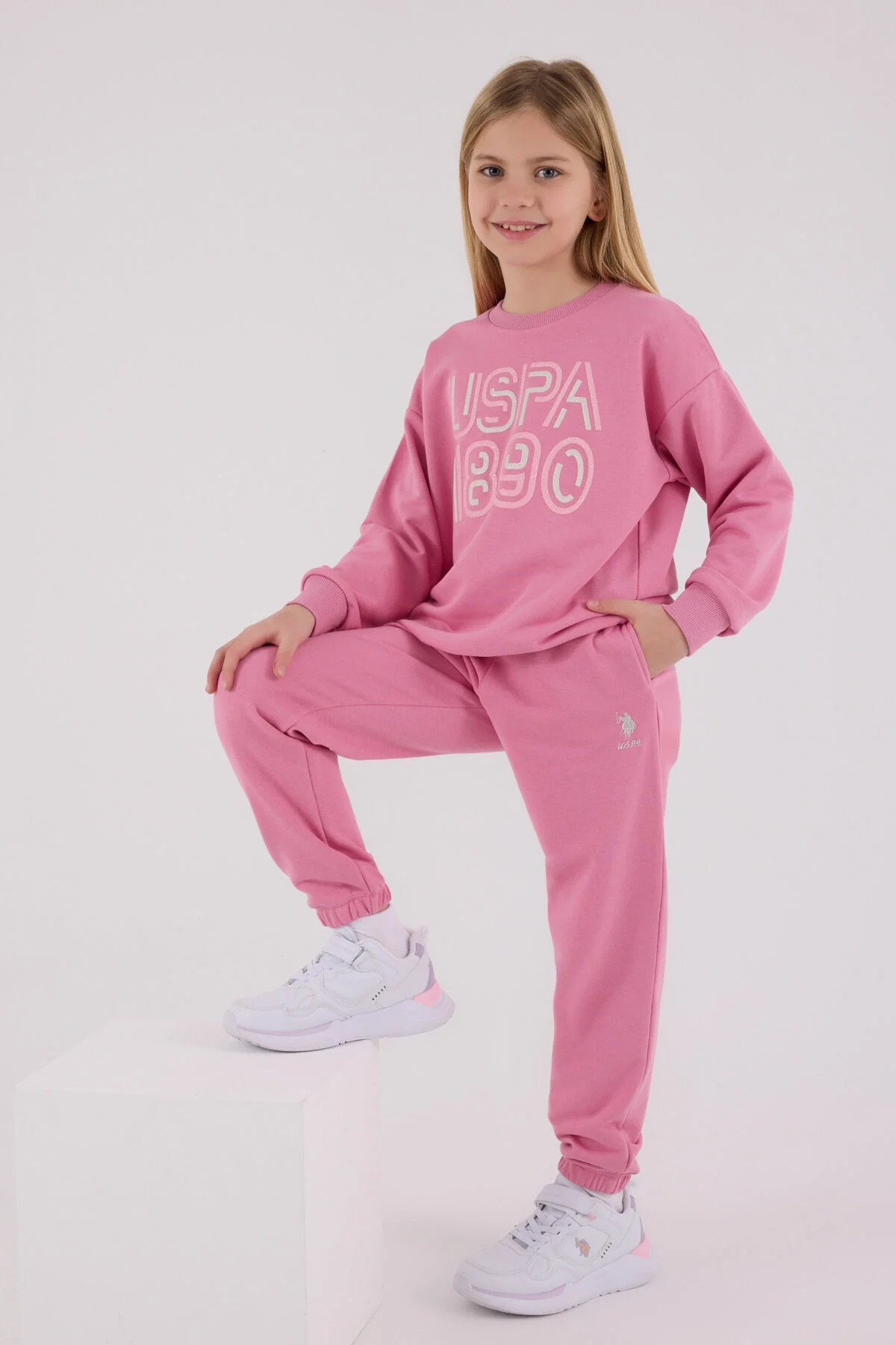 Pembe USPA 1890 yazışma eşofman takımı, kız çocuk spor giyim, model ön görünüm, beyaz arka plan