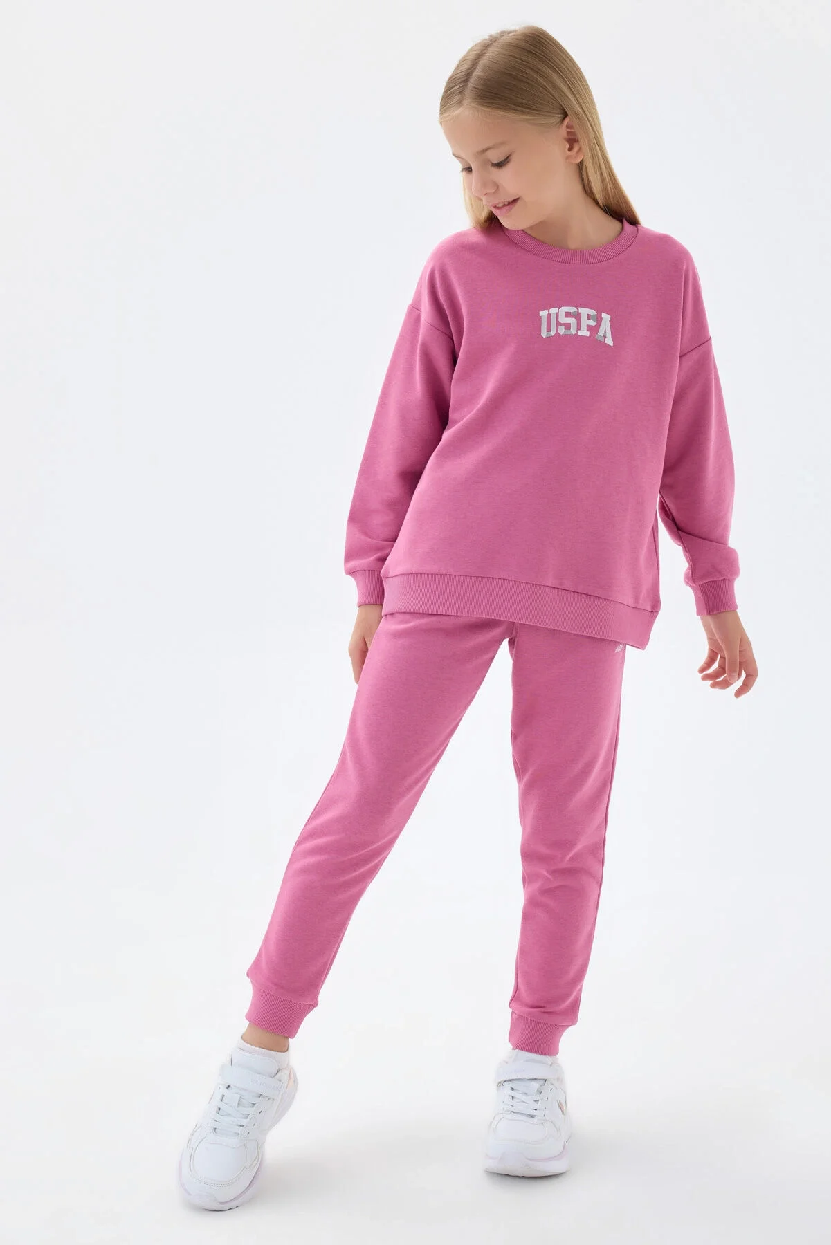 Pembe USPA markalı kız çocuk eşofman takımı, uzun kollu üst ve pantolon, eğlenceli Lego blok arka planında