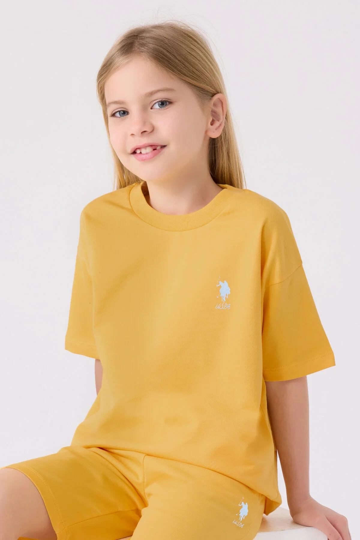 Sarı U.S. Polo Assn Kız Çocuk Bermuda Takım, çocuk spor kıyafetleri, marka logosu, beyaz spor ayakkabılarla takımlı