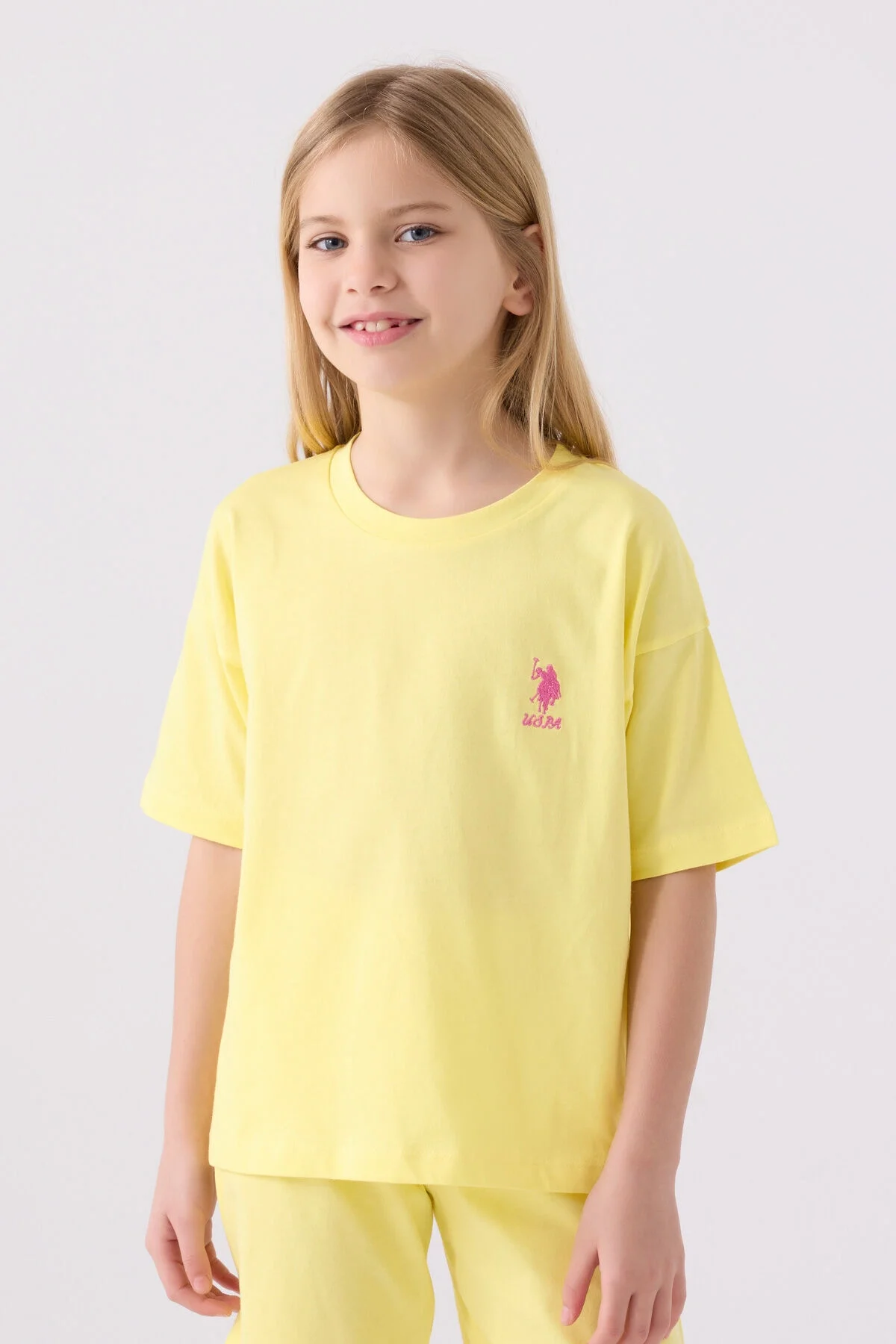 Sarı U.S. Polo Assn kız çocuk Bermuda takım, ön ve yan görünüm, pembe logo, beyaz spor ayakkabılar