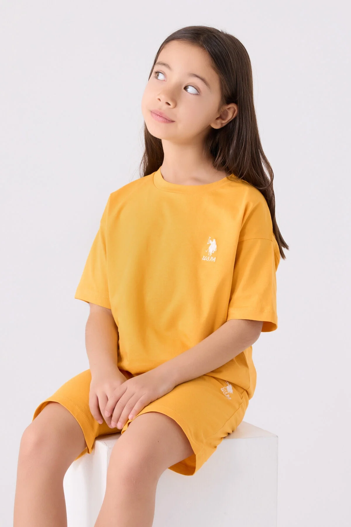 Sarı U.S. Polo Assn kız çocuk Bermuda takım elbette, ön detaylı, model pozisyonu, marka logosu