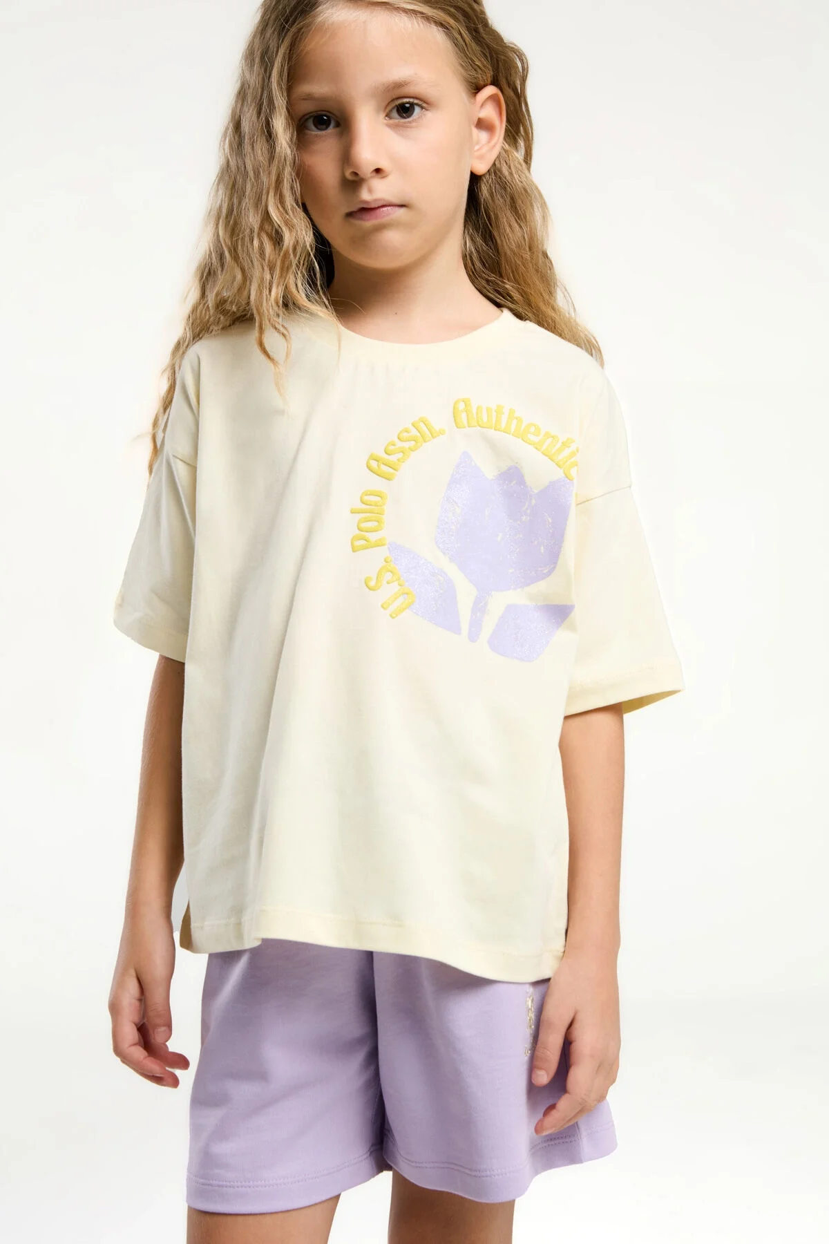 U.S. Polo Assn kız çocuk sarı ve mor şort takım, ön ve yan görünüm, marka logosu