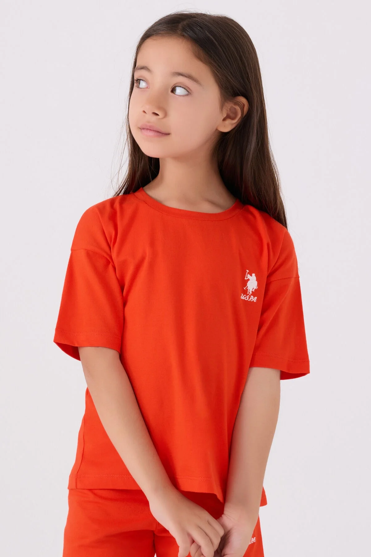 U.S. Polo Assn kız çocuk turuncu Bermuda takım seti, ön ve yan görünüm, marka logosu, beyaz arka plan