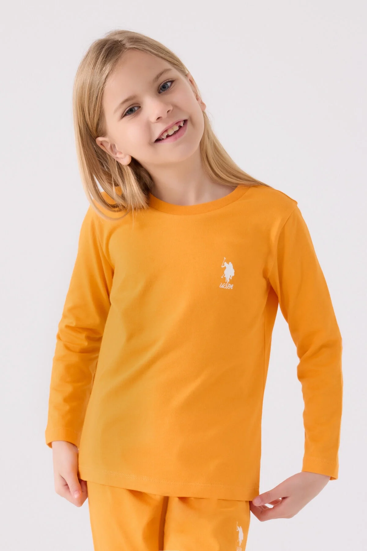 Turuncu U.S. Polo Assn kız çocuk pijama takımı, uzun kollu üst ve pantolon, marka logosu, beyaz arka plan