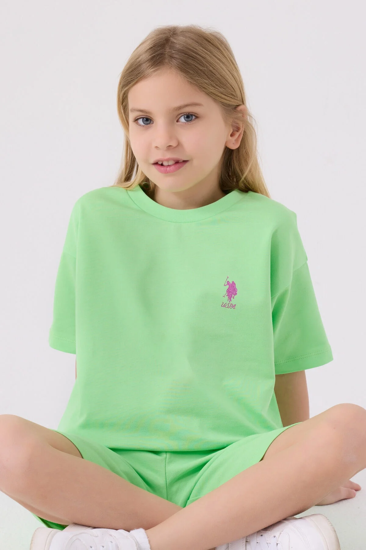 Yeşil U.S. Polo Assn kız çocuk Bermuda takım elbette, model ön görünüm, parlak renkli spor kıyafet